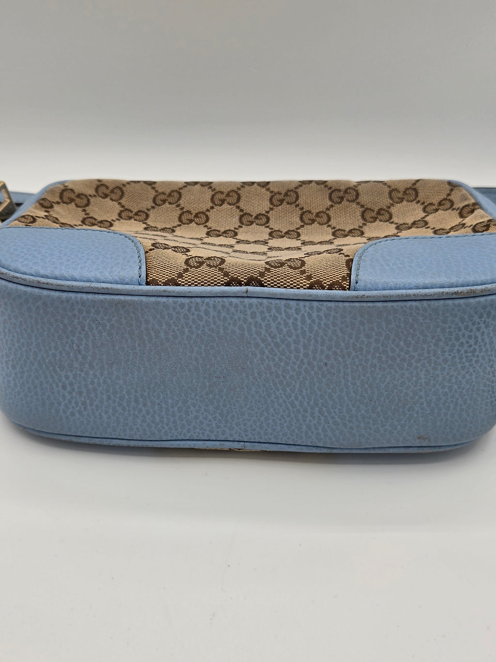 Blue pouch with patterned side on a light gray background