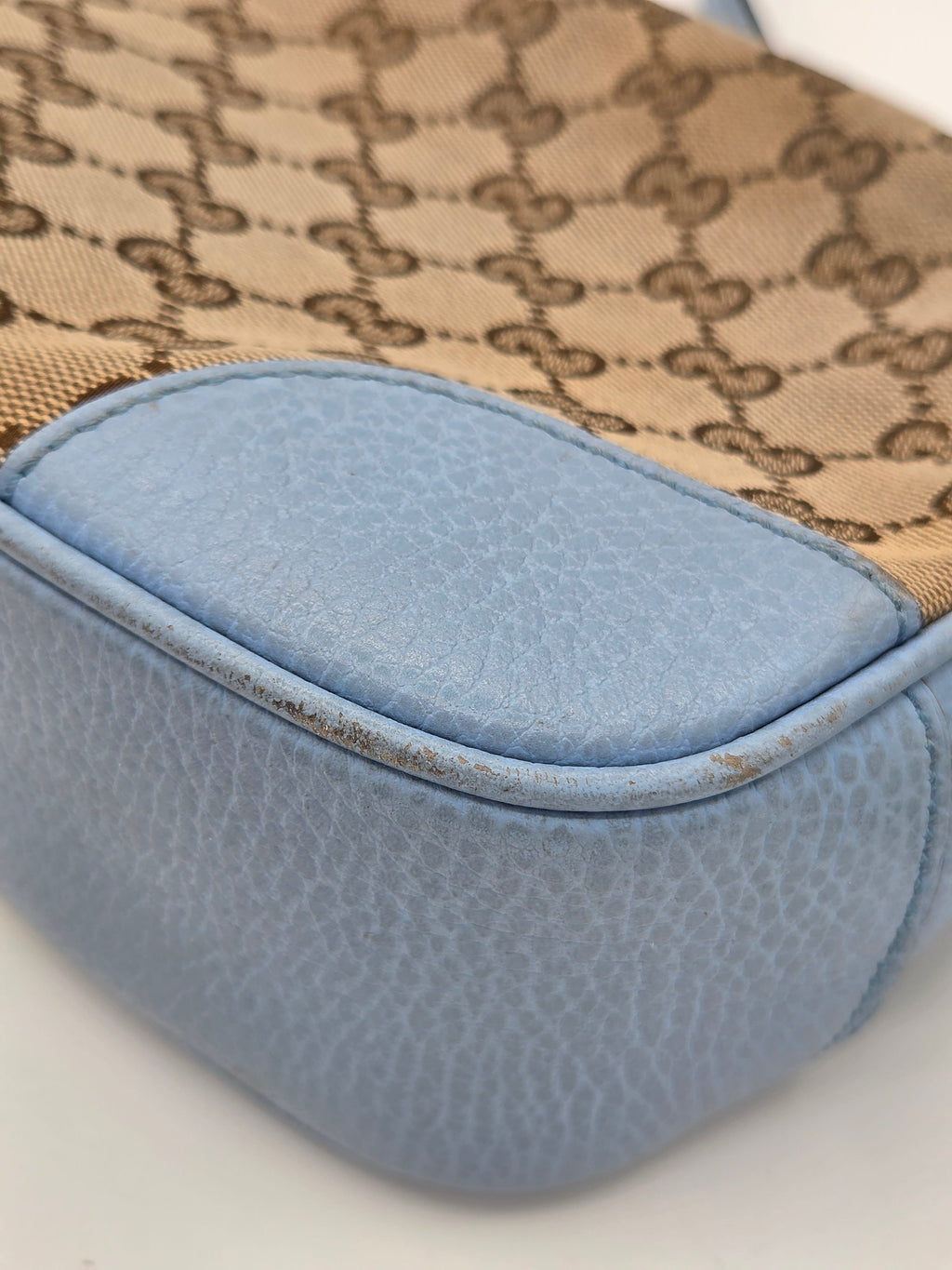 Close-up of a patterned fabric with a blue patch on a neutral background