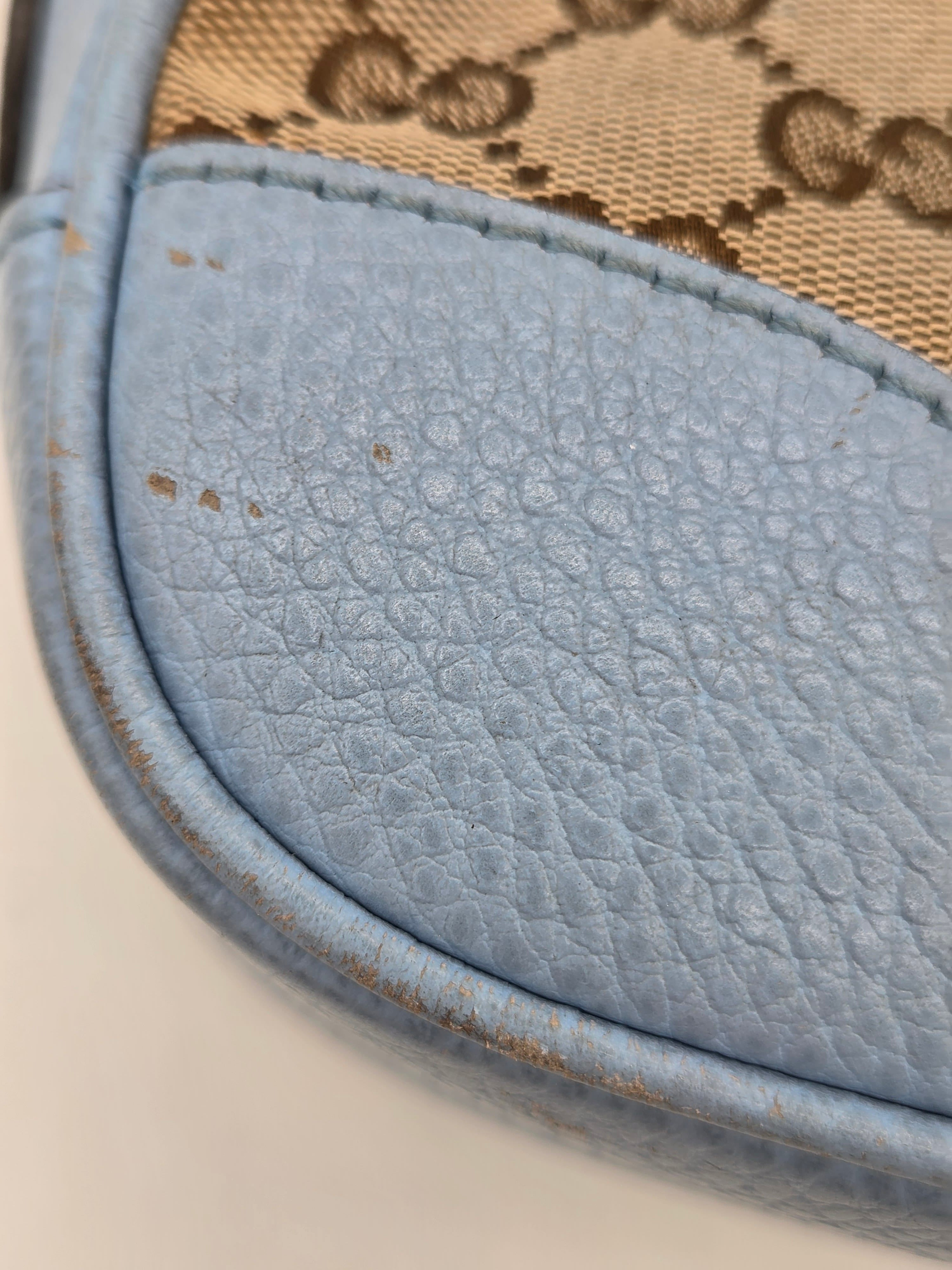 Close-up of a textured blue leather patch on a beige fabric background