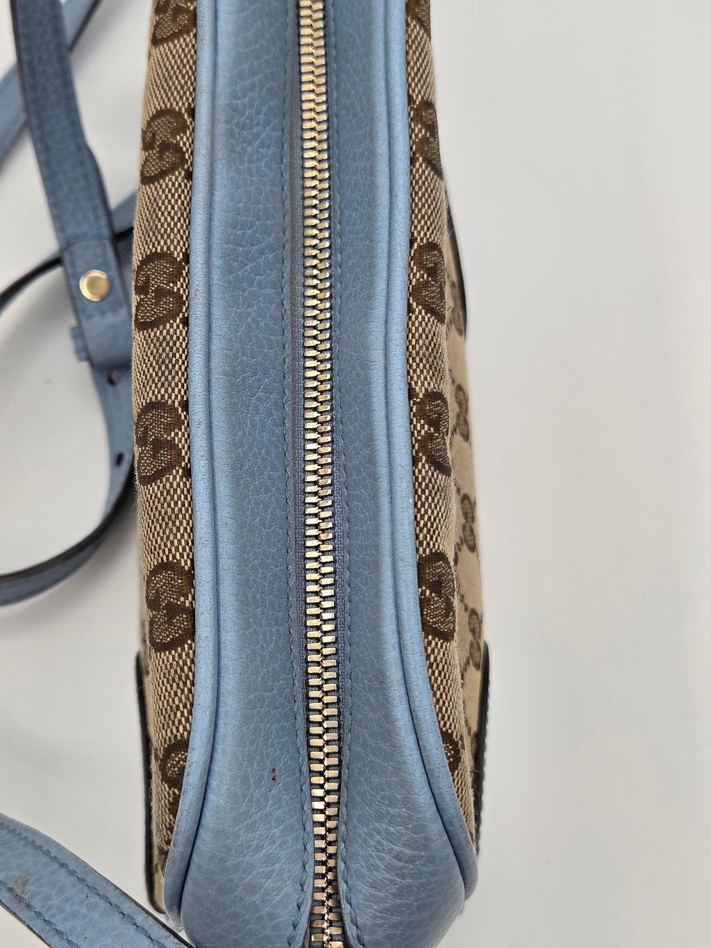 Blue handbag with a patterned flap on a light gray background