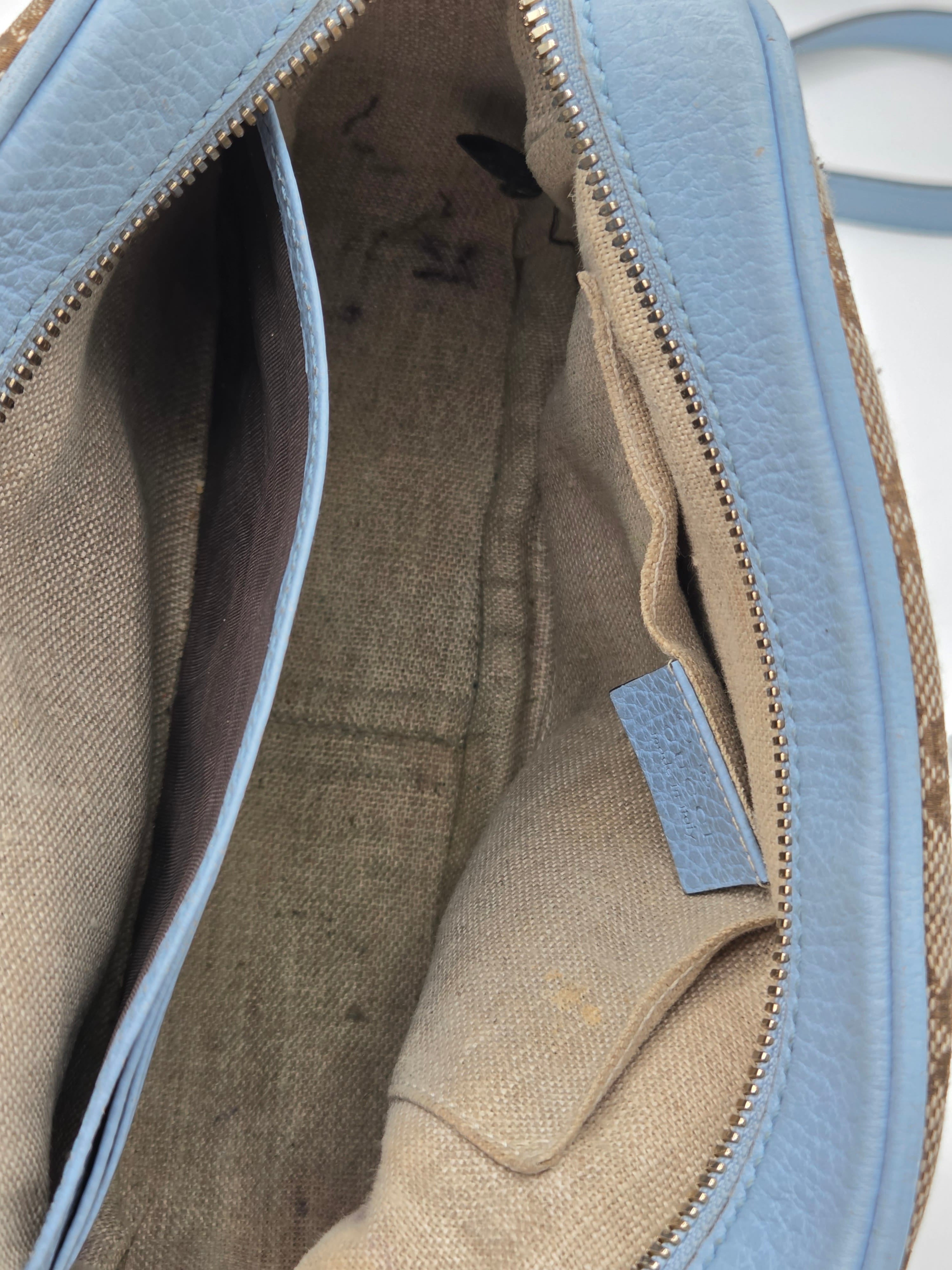 Close-up of a blue and beige handbag with visible wear and tear.