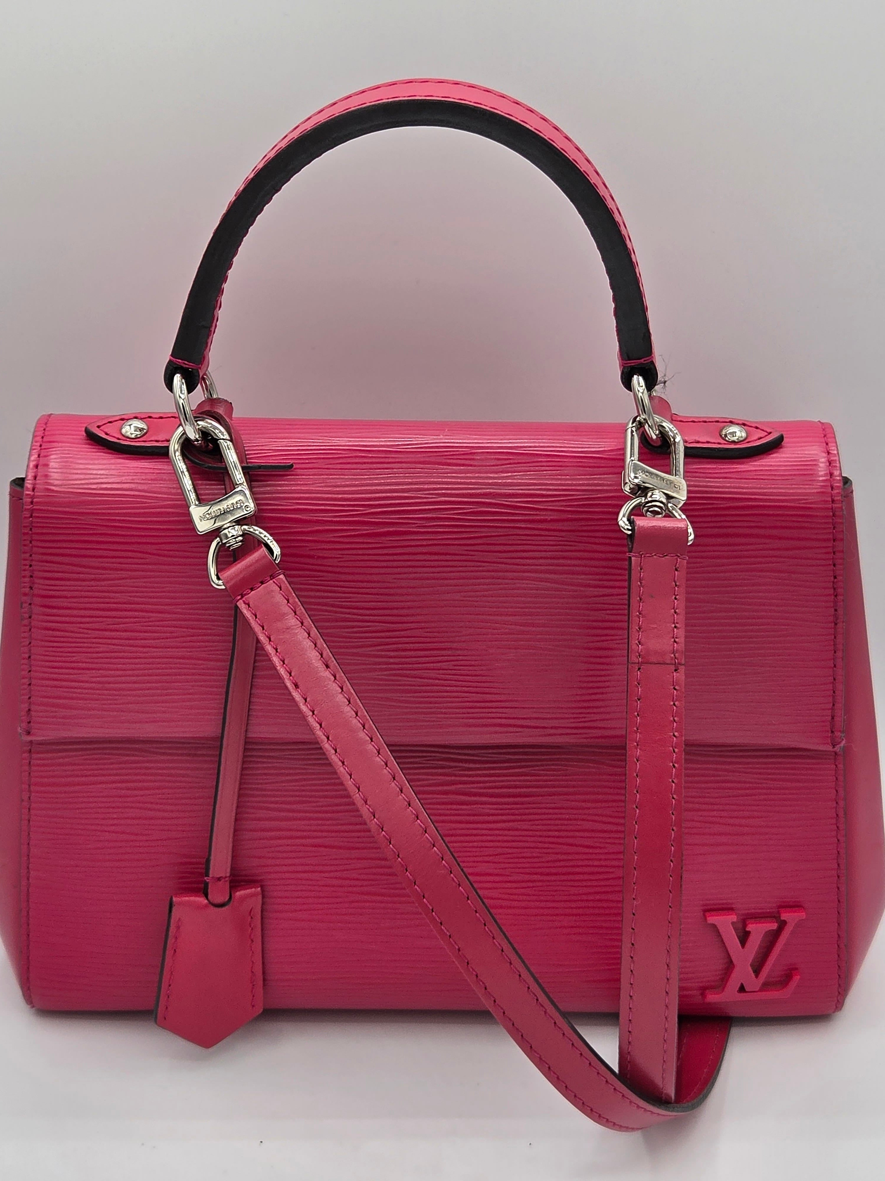 Red handbag with a visible brand logo on a light gray background