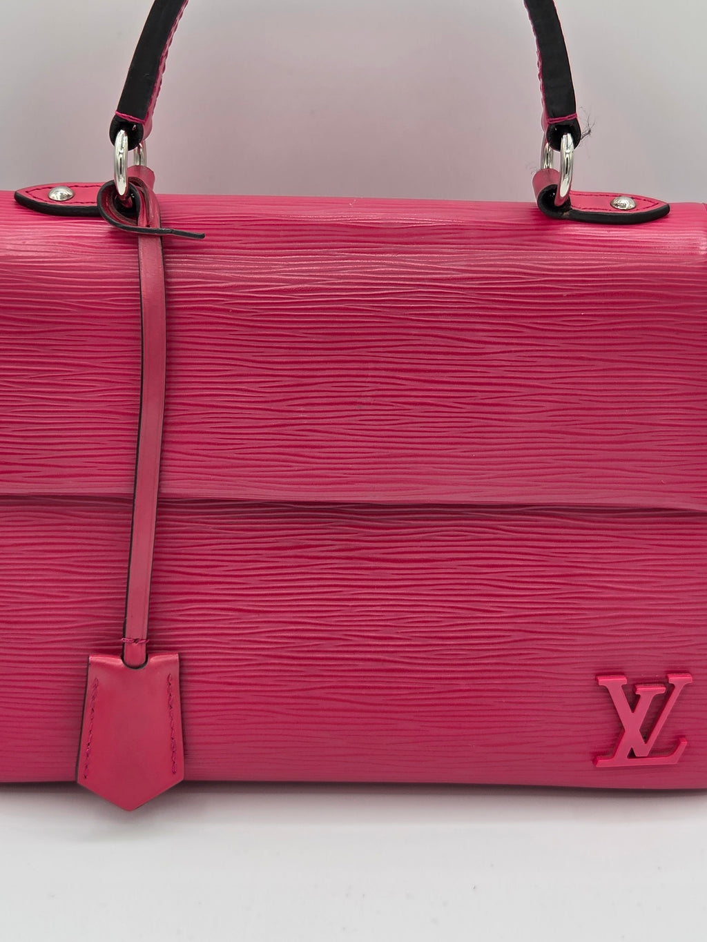 Pink handbag with a visible brand logo on a light gray background