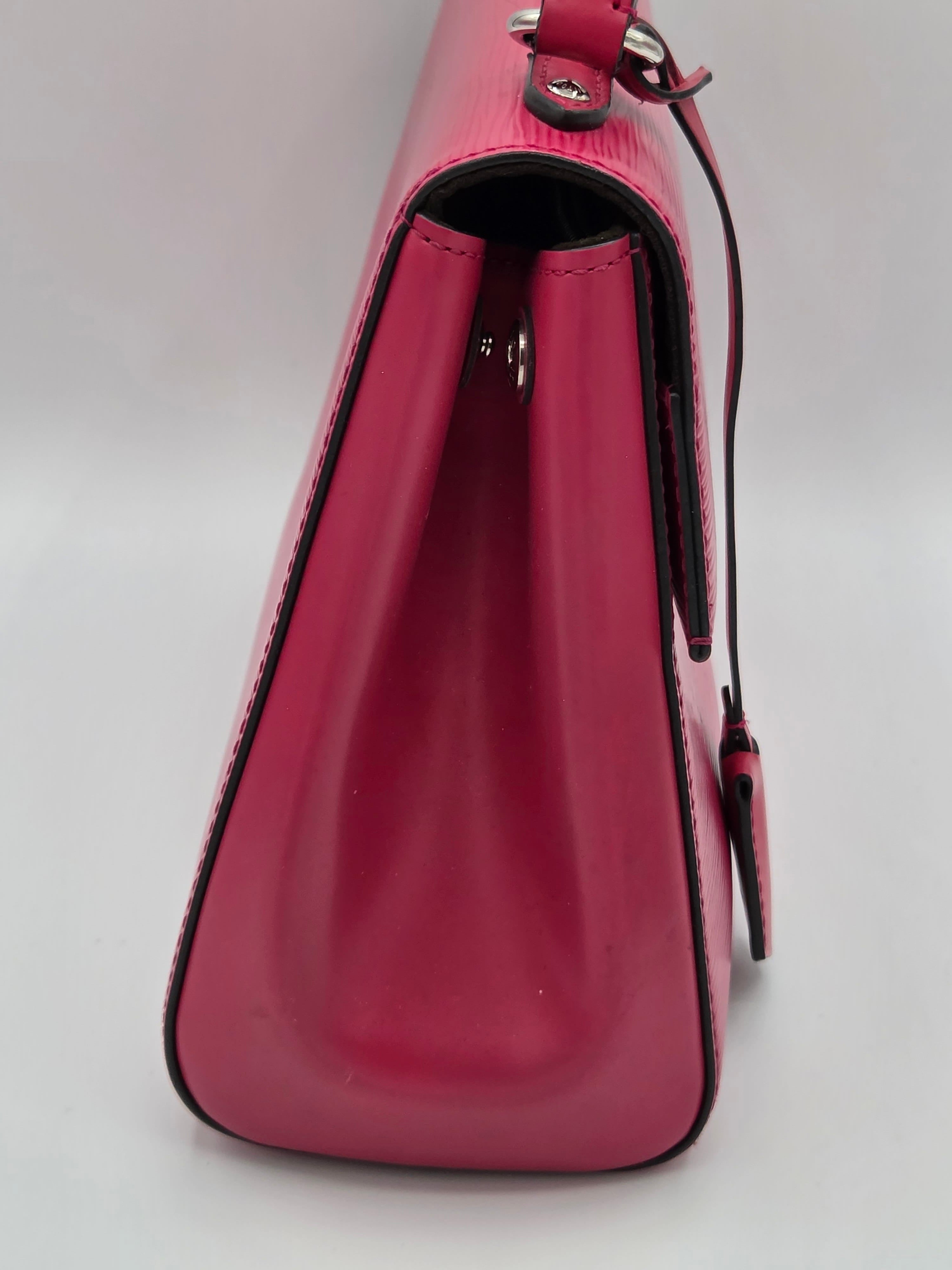Pink leather handbag with a zipper on a light gray background