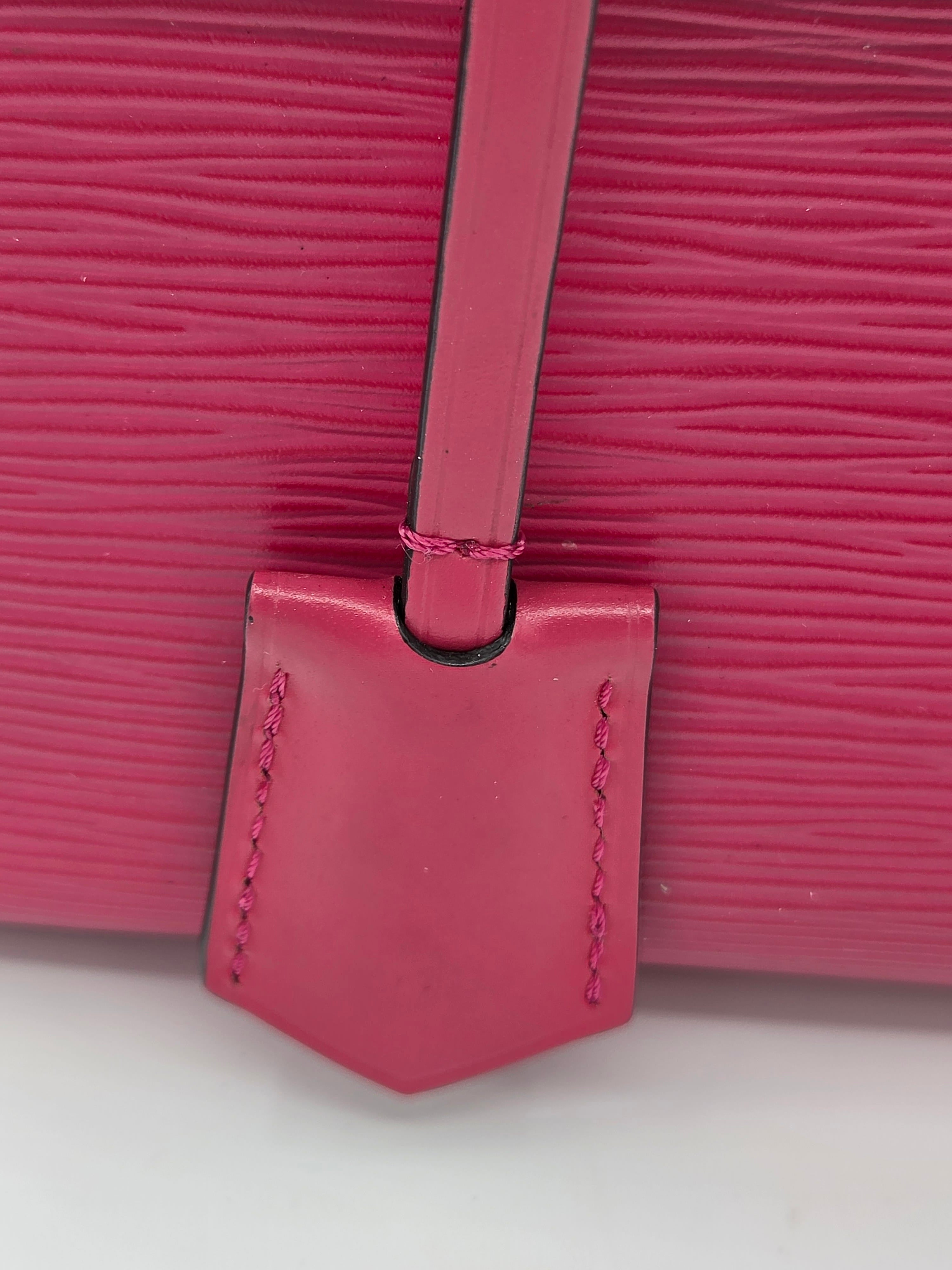 Close-up of a pink textured handbag with a strap on a white background