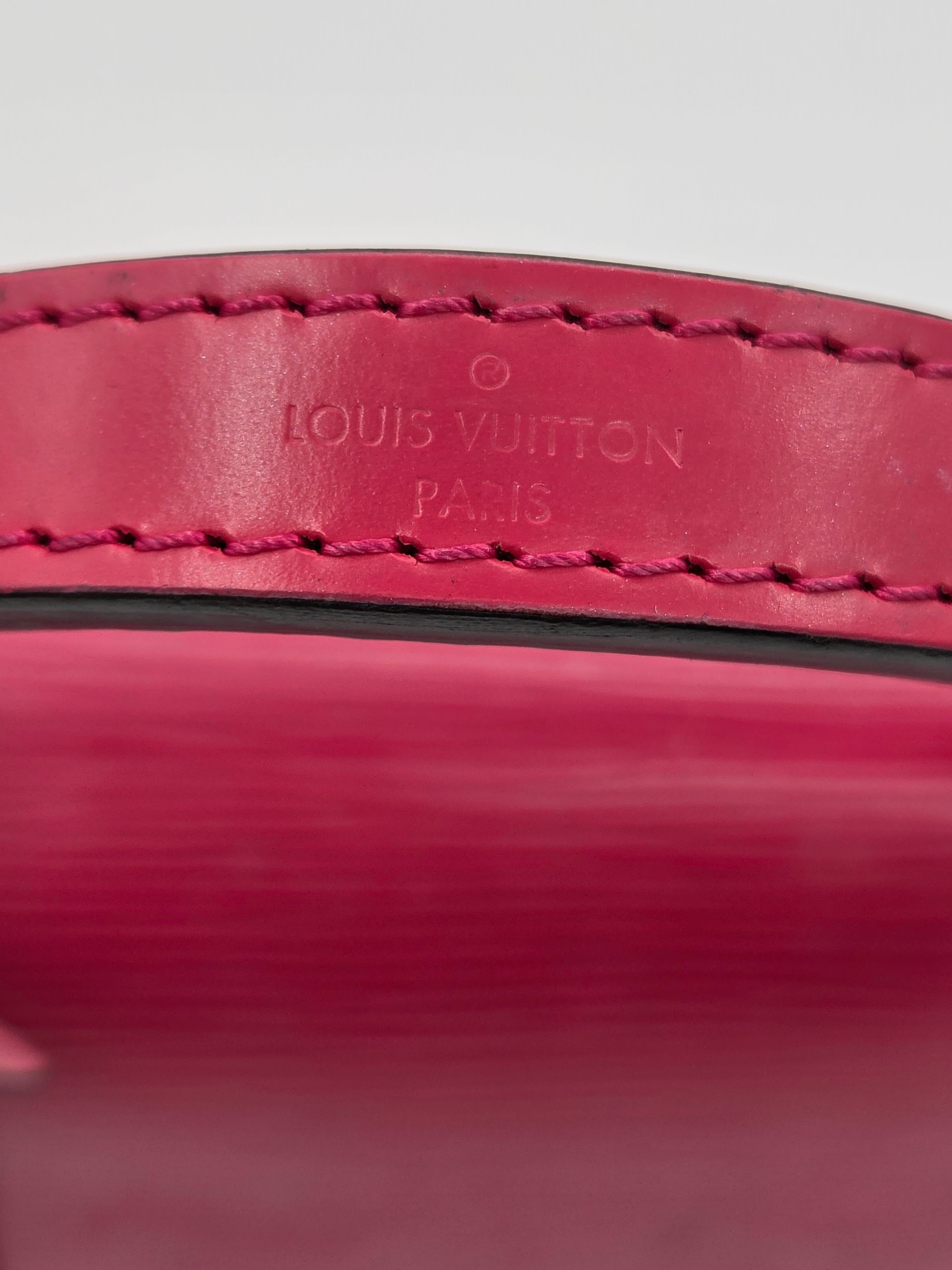 Close-up of a red leather product with 'Louis Vuitton' branding.
