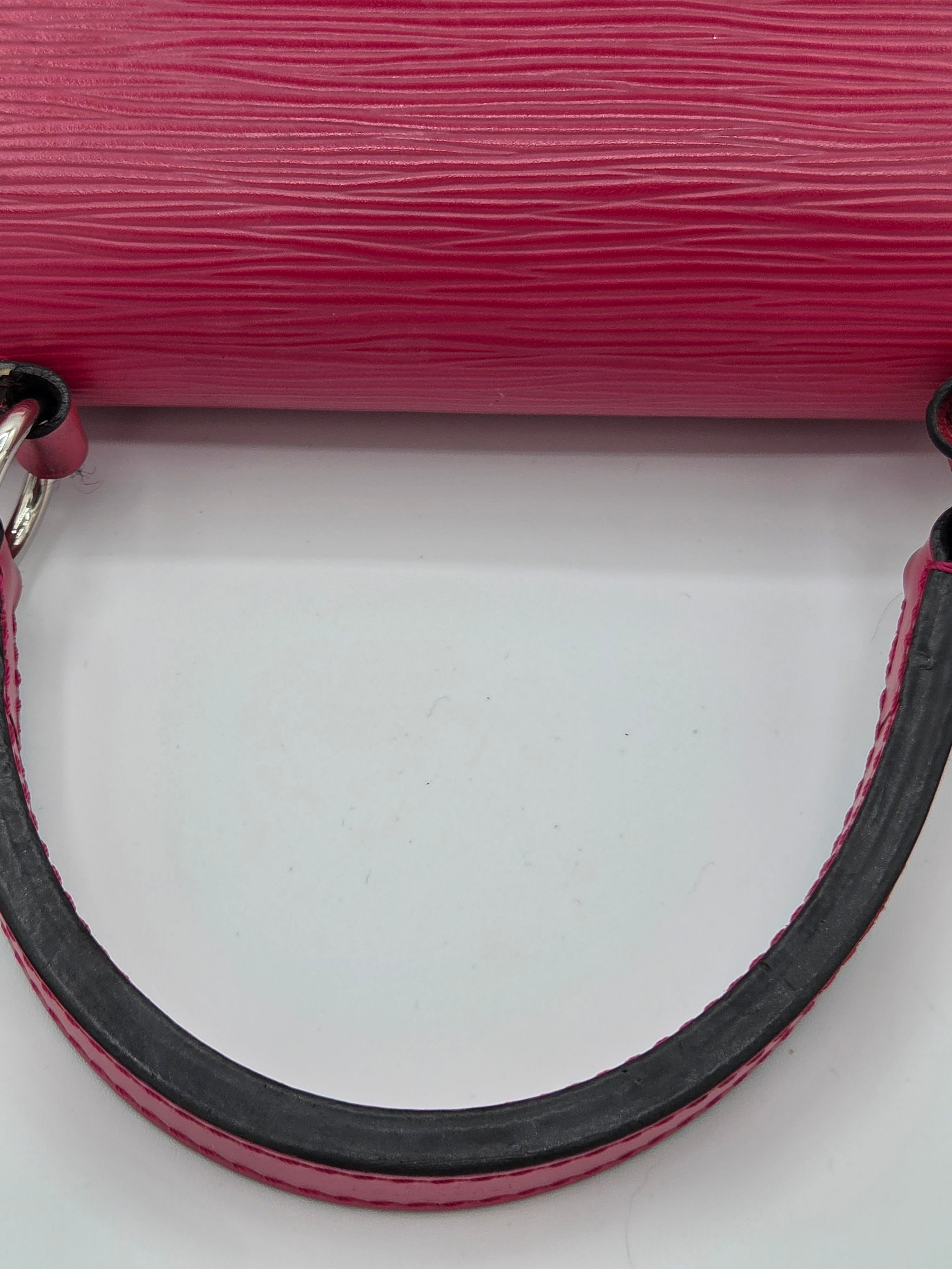 Close-up of a pink textured handbag handle on a light gray background