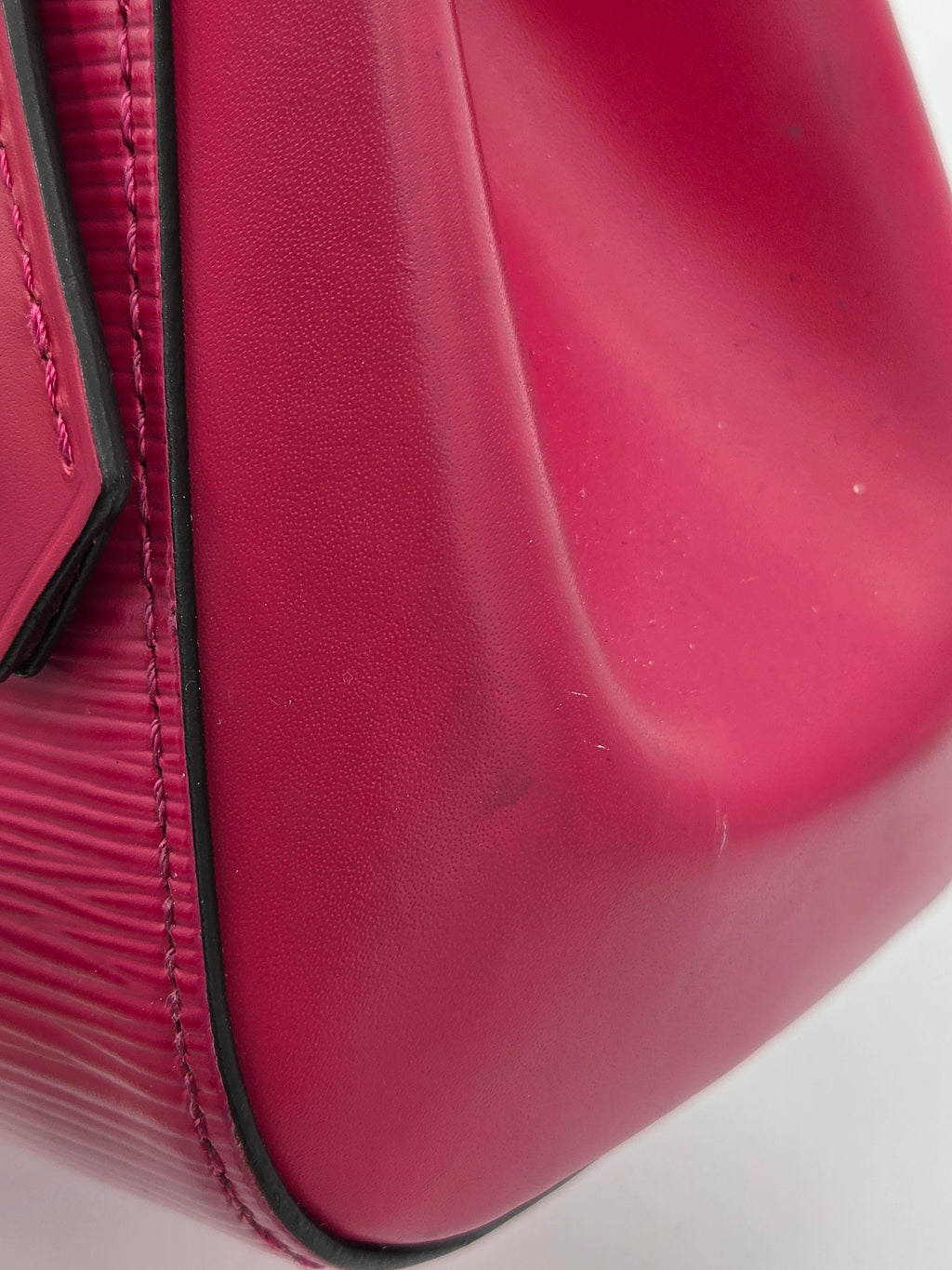 Close-up of a red suitcase with visible texture and corner.