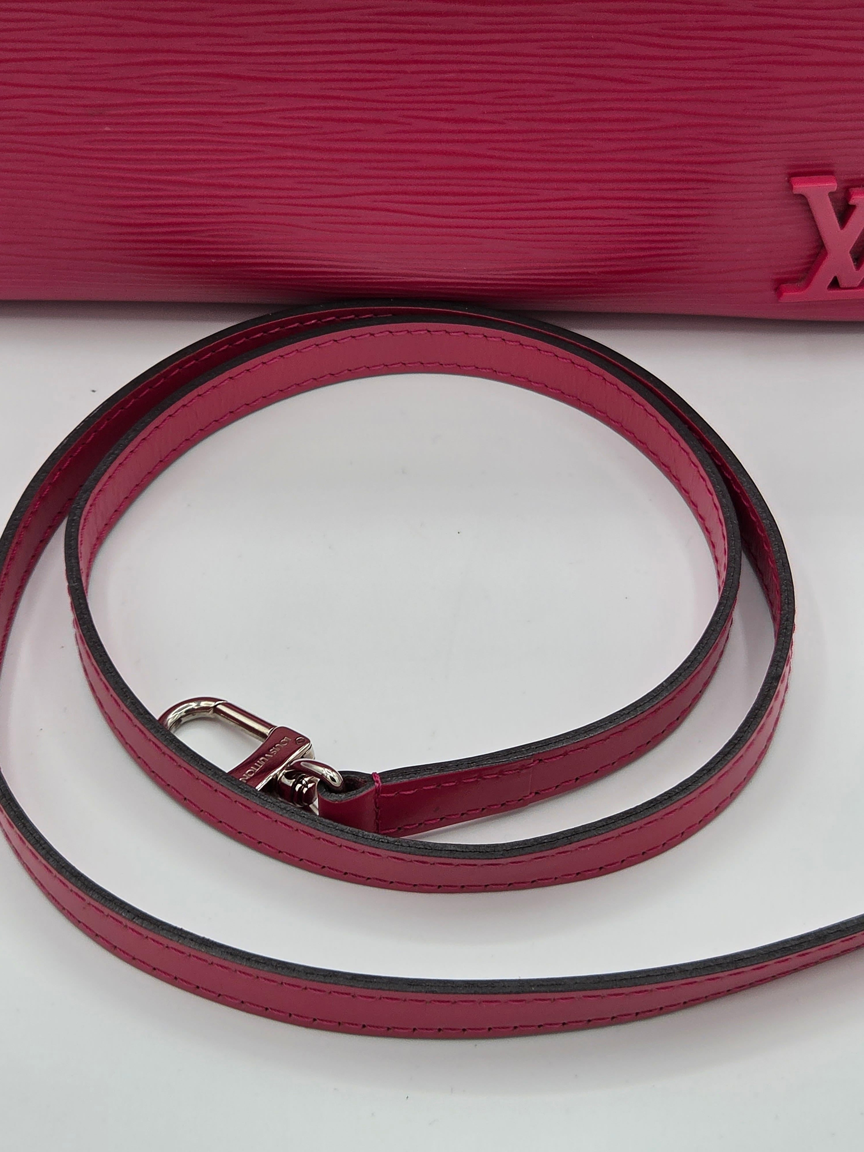 Close-up of a red leather strap with a silver buckle on a white background