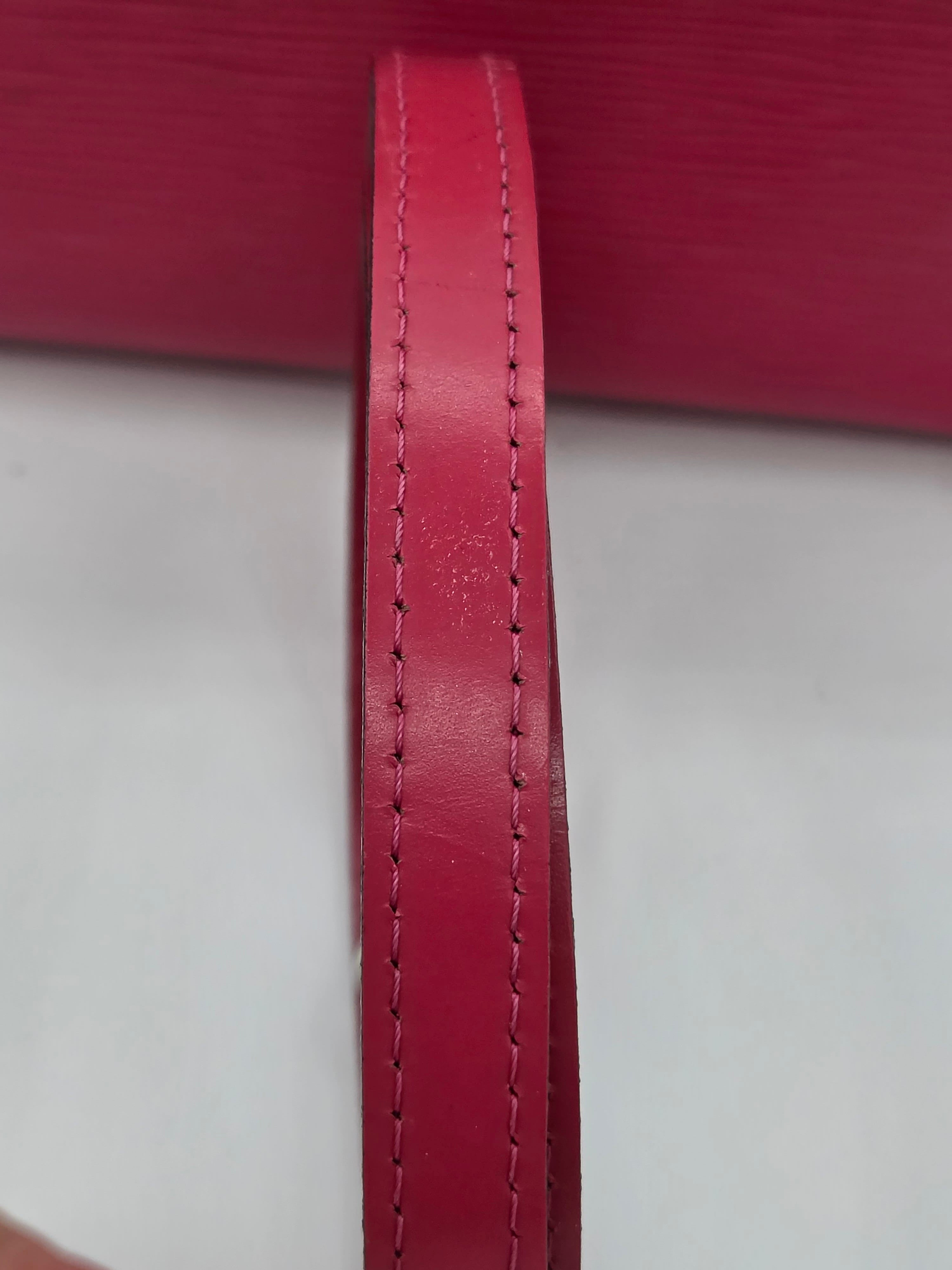 Close-up of a red leather strap with stitching on a white background