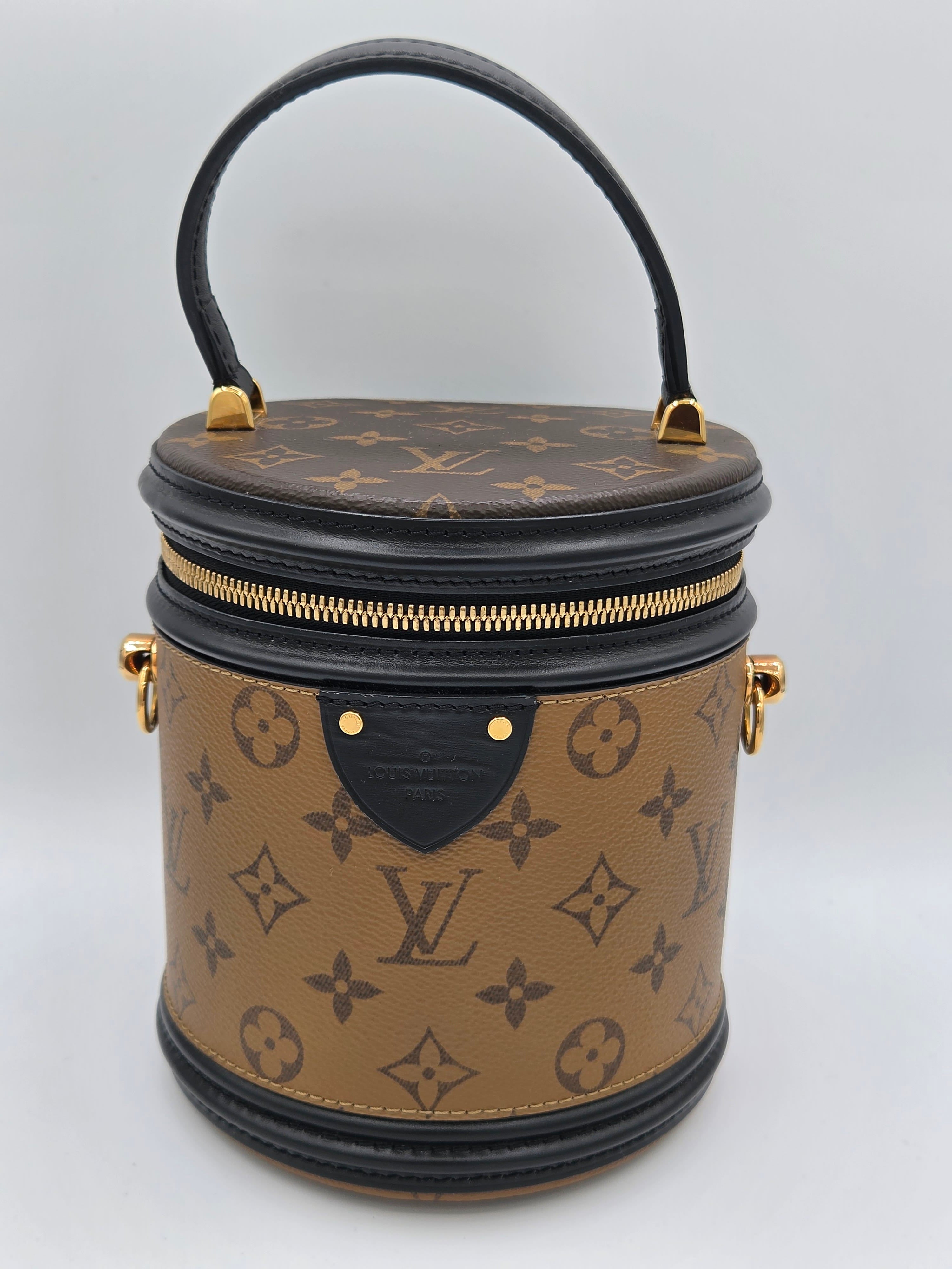 Designer handbag with monogram pattern on a light gray background