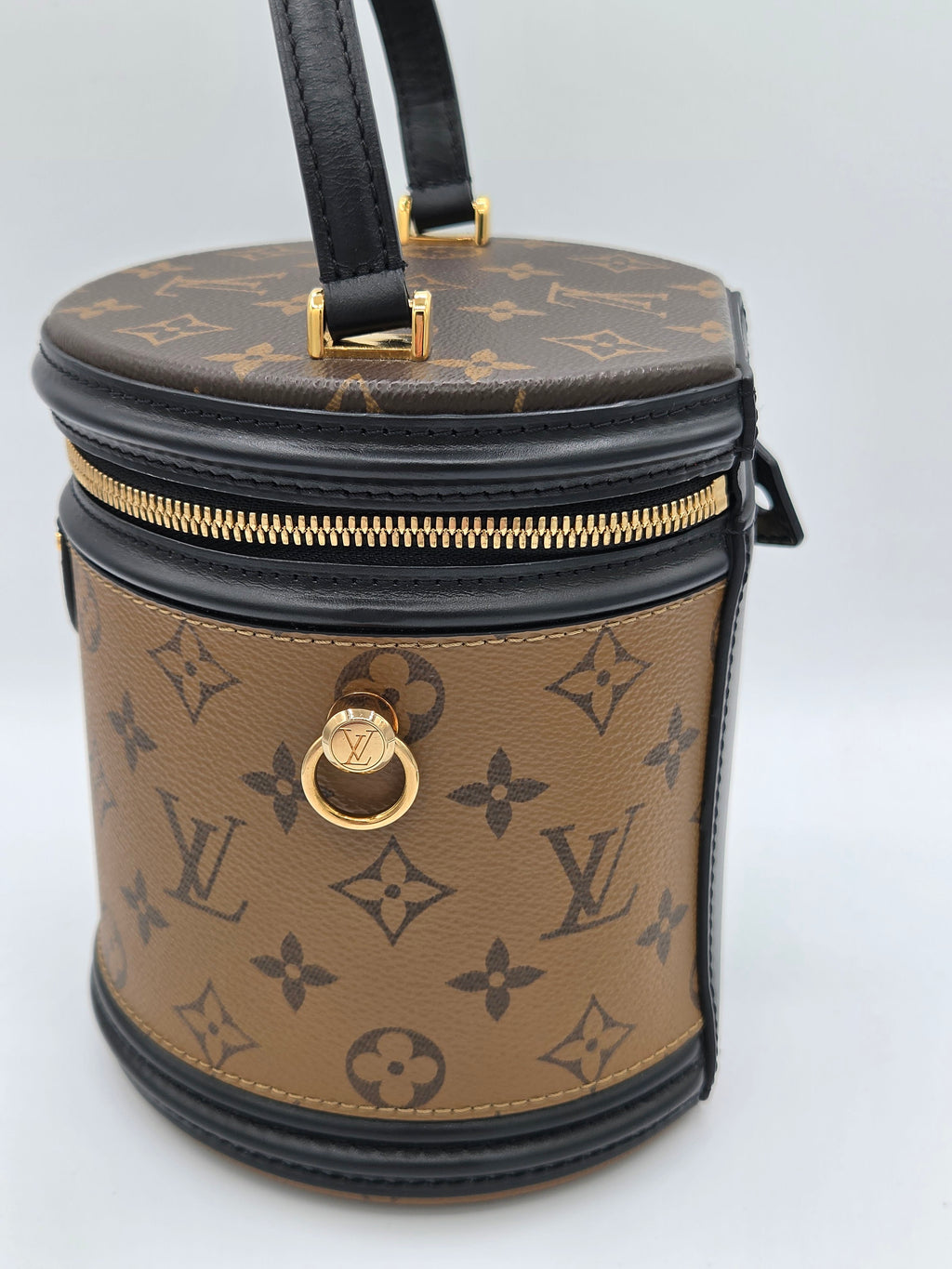 Designer handbag with monogram pattern on a light gray background