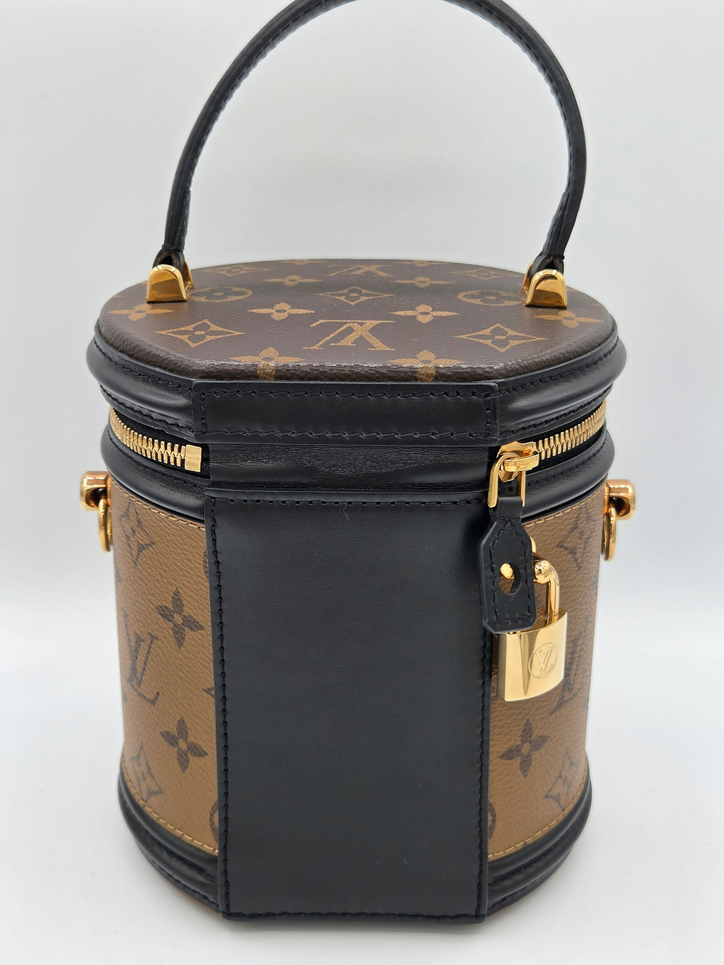 Designer handbag with monogram pattern on a light gray background