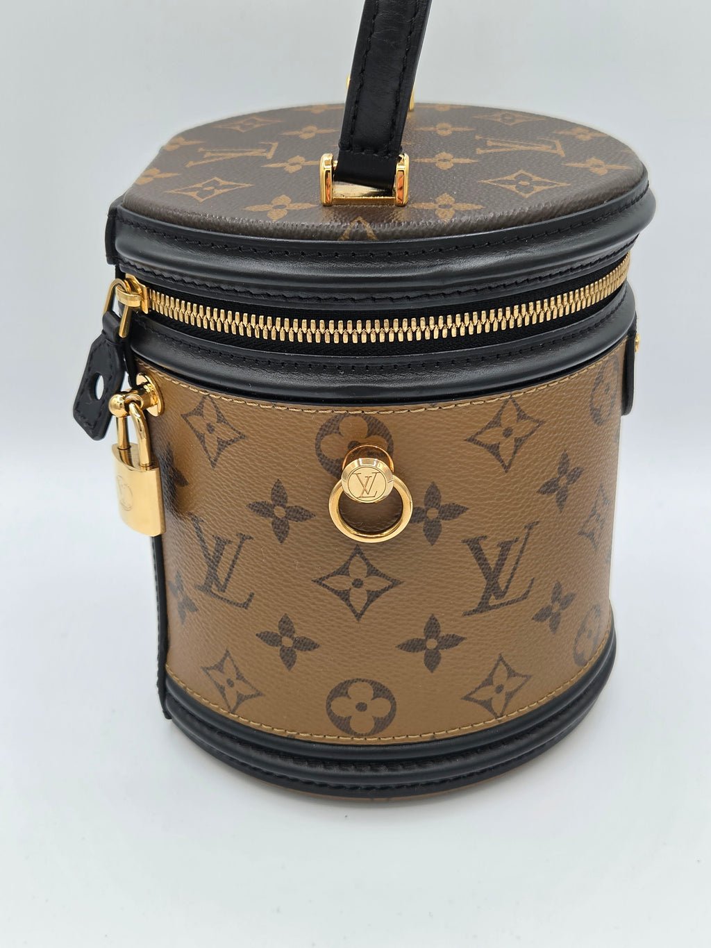 Designer handbag with monogram pattern on a light gray background
