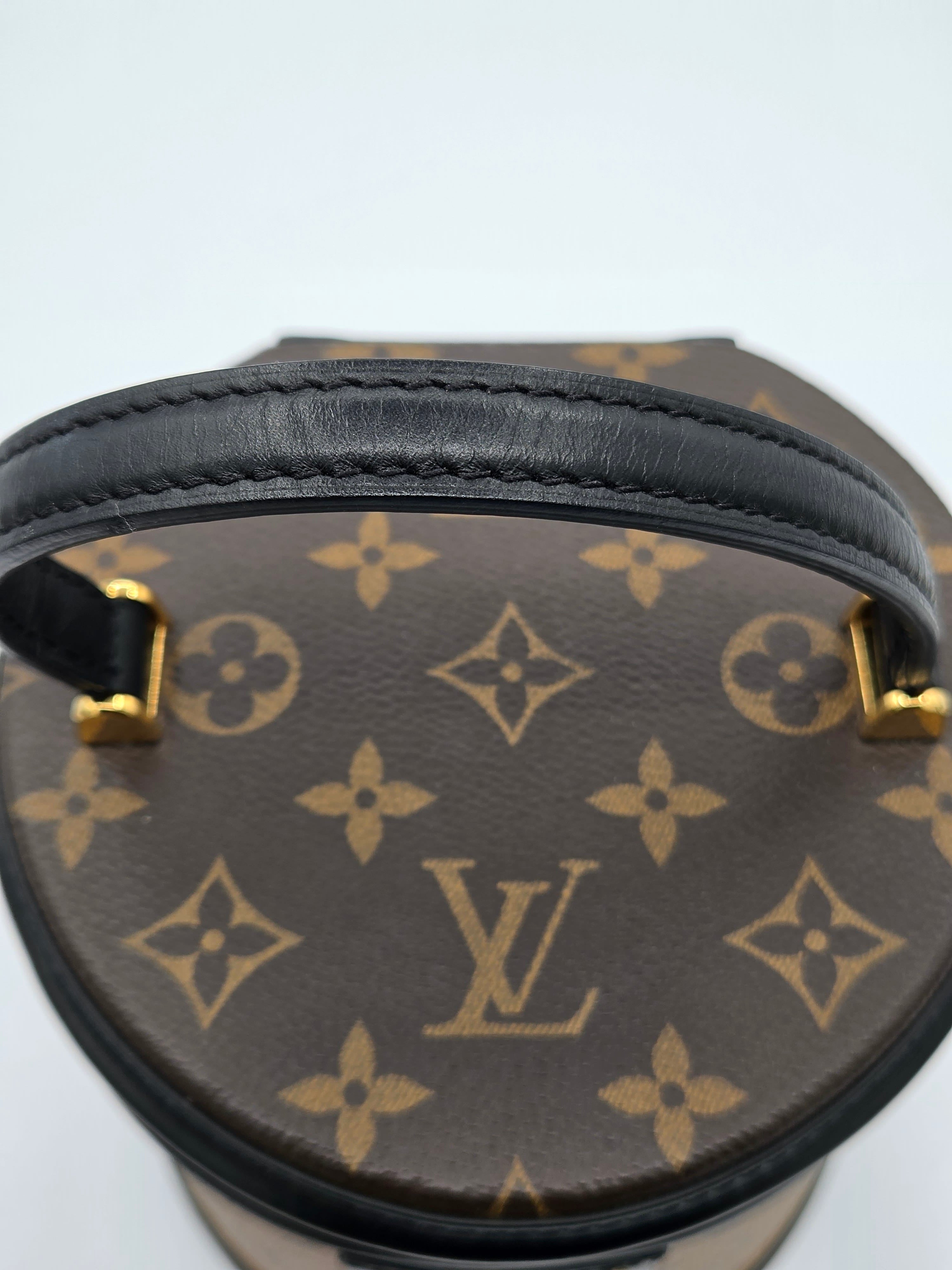 Round handbag with monogram pattern on a light gray background