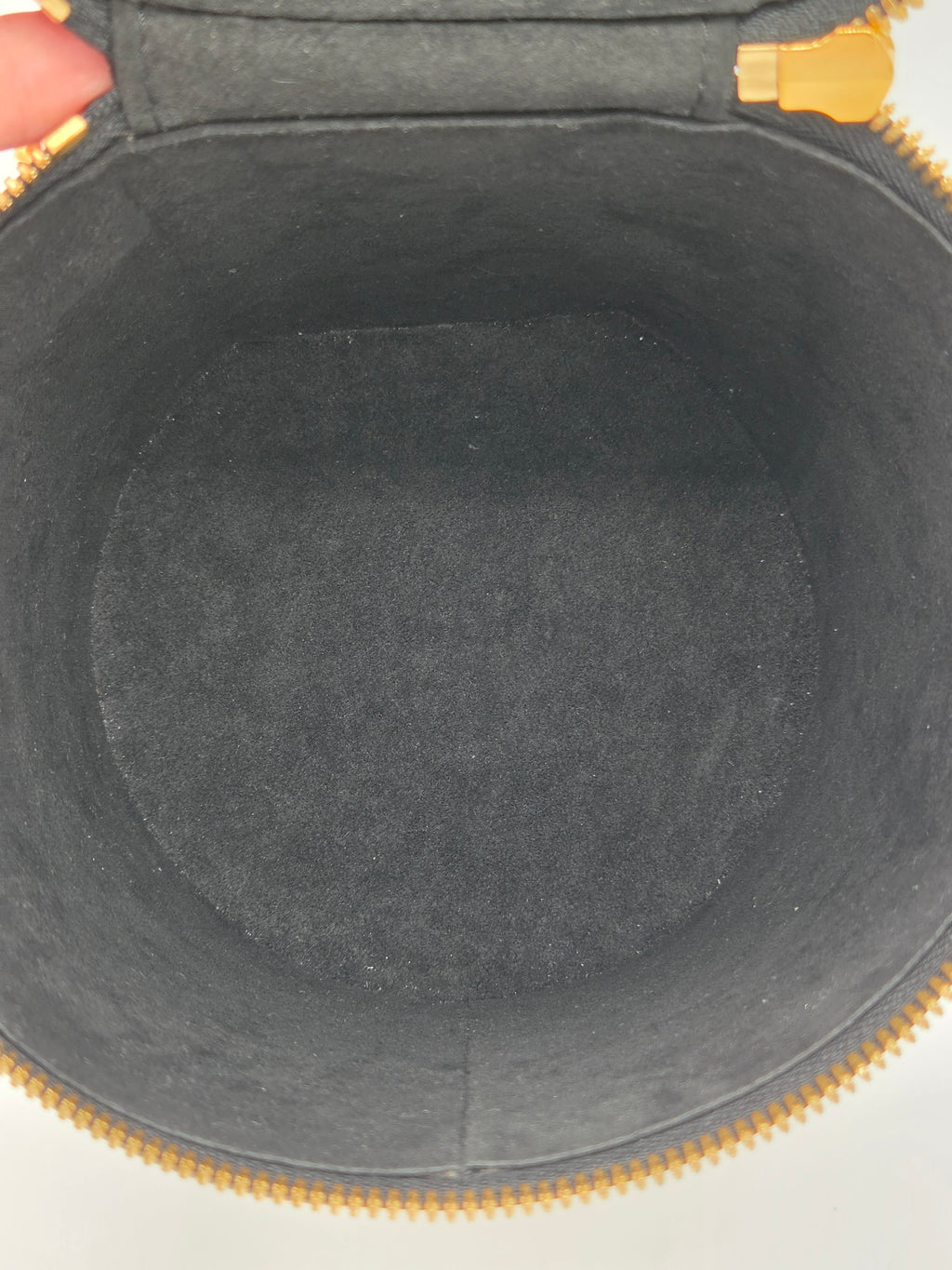 Close-up of a gray interior of a bag with gold zipper.