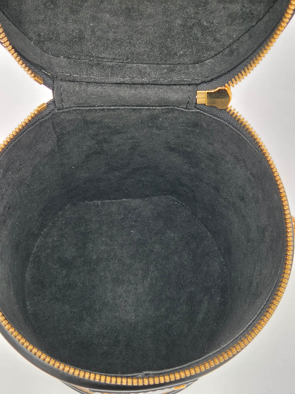 Black round case with gold trim on a white background