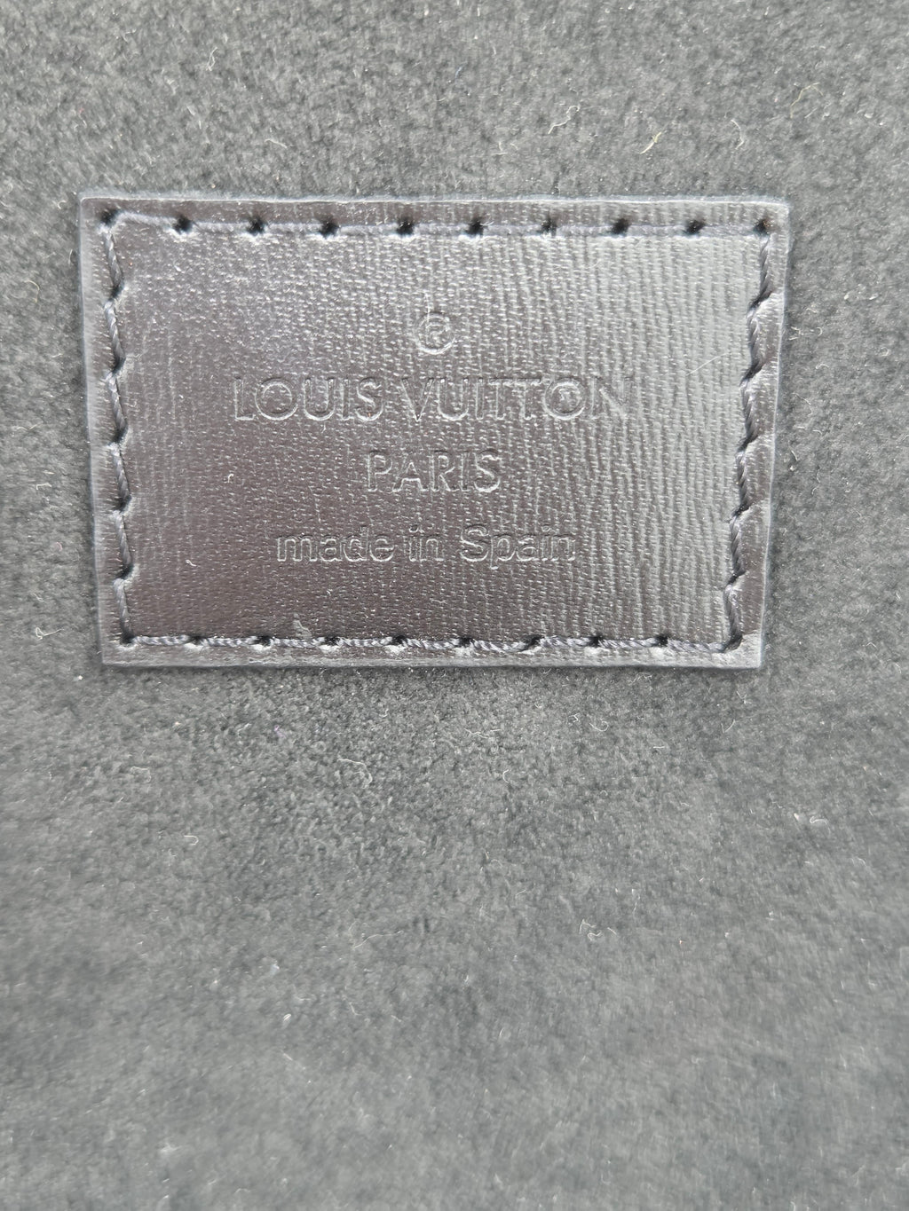 Louis Vuitton label on a textured surface