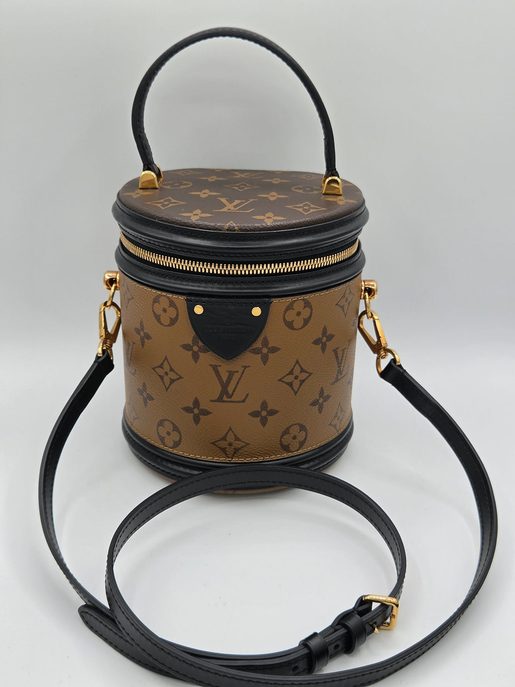 Designer handbag with monogram pattern on a light gray background