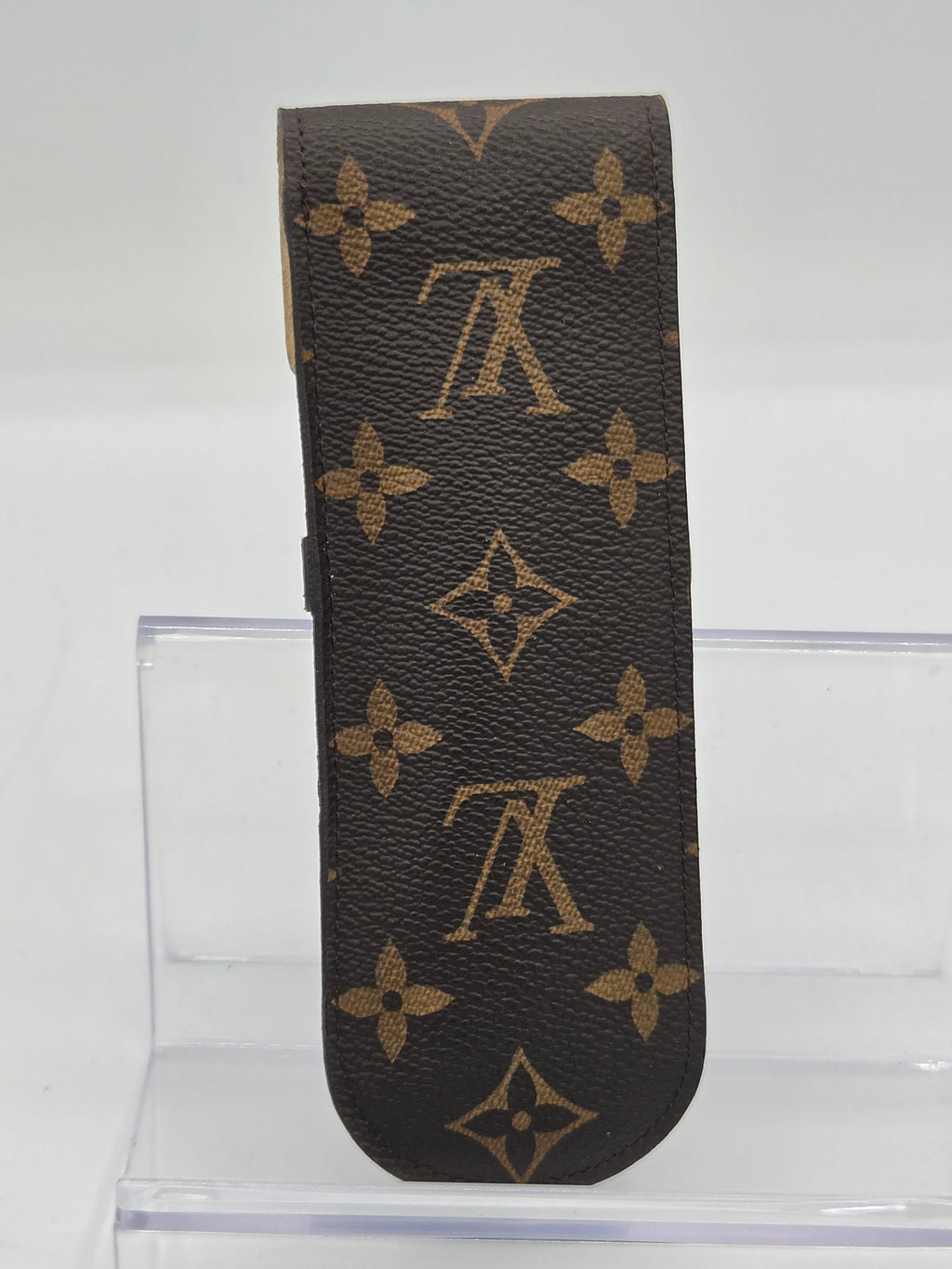 Louis Vuitton monogram canvas key case in brown and tan, shown against a white background with a clear acrylic stand.