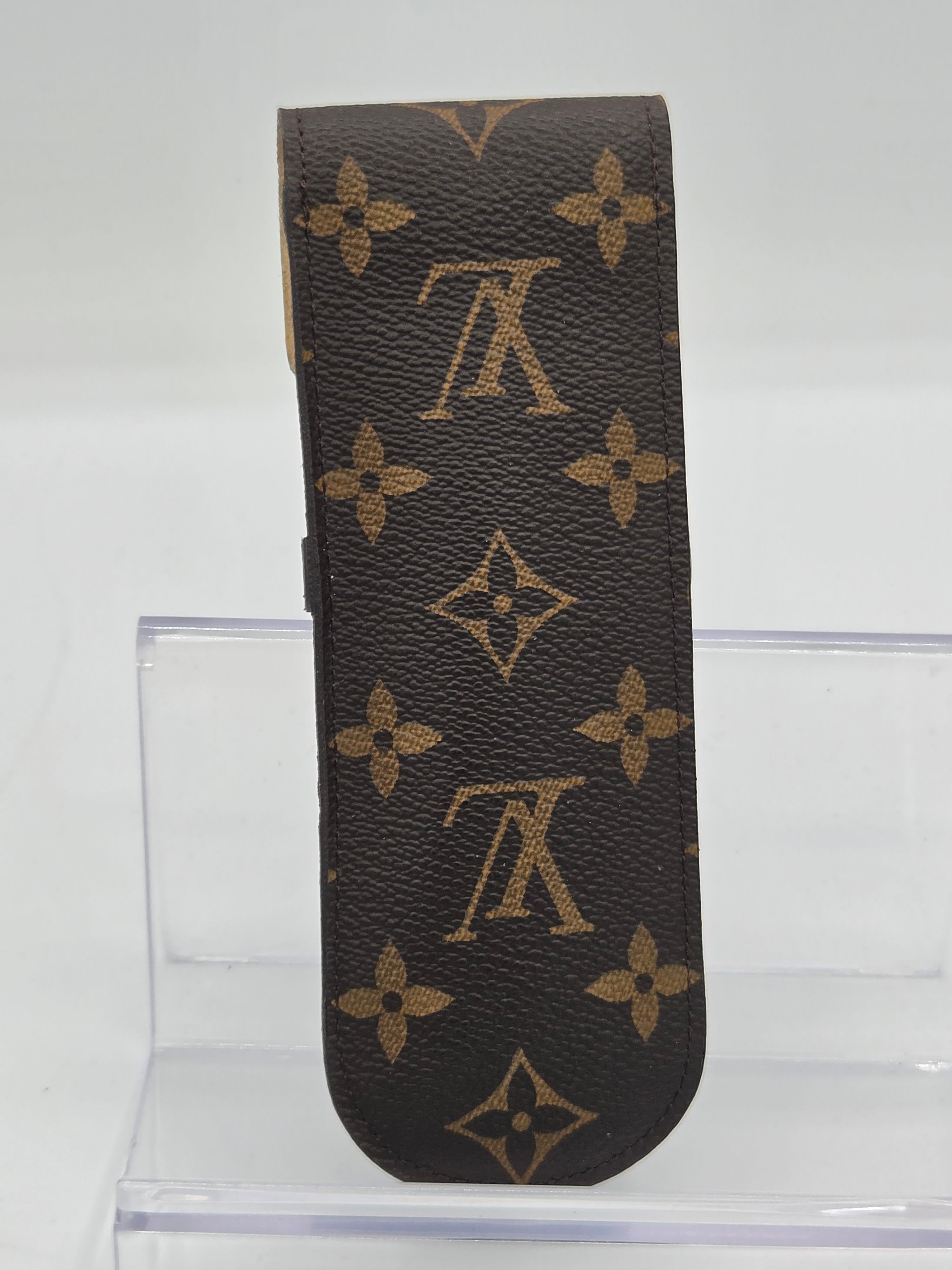 Louis Vuitton monogram canvas key case in brown and tan, shown against a white background with a clear acrylic stand.