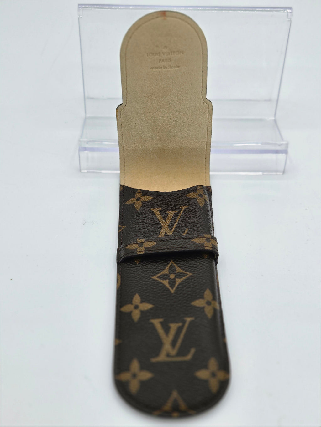 Louis Vuitton monogram canvas strap with a tan leather footbed, displayed on a clear acrylic stand against a white background.
