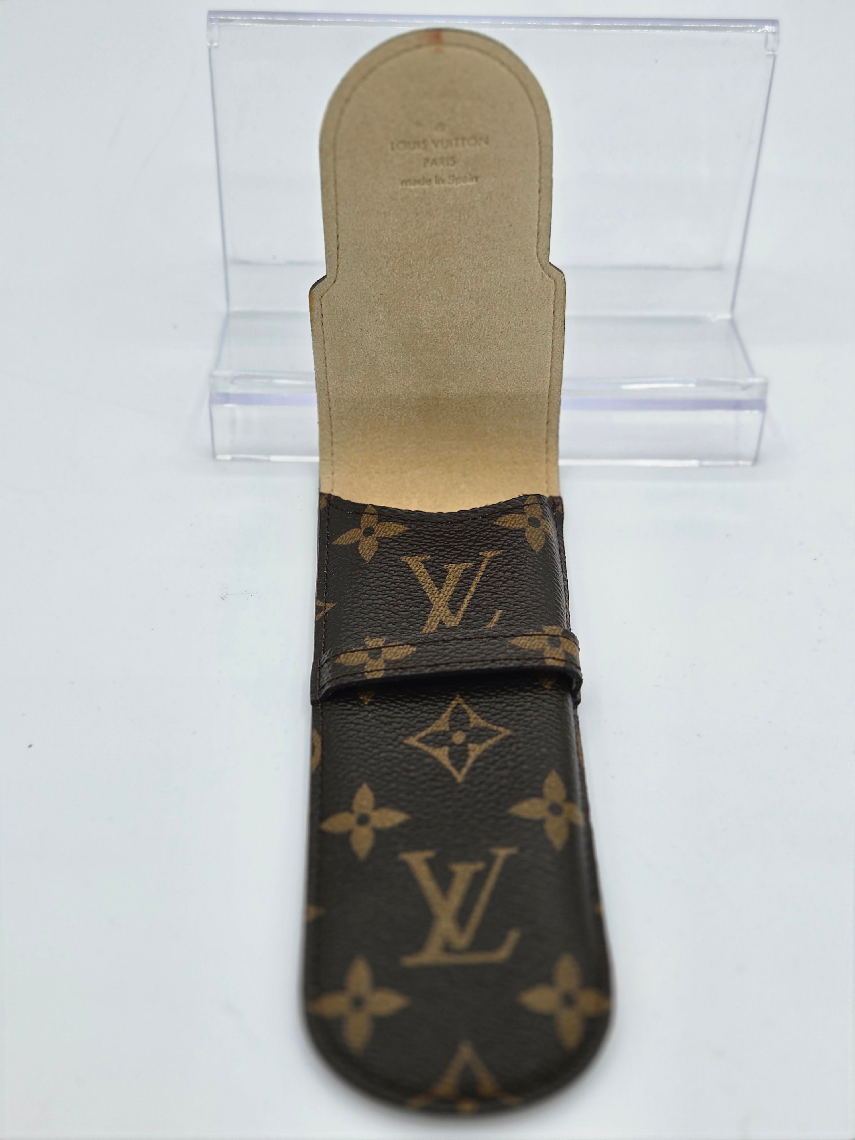Louis Vuitton monogram canvas strap with a tan leather footbed, displayed on a clear acrylic stand against a white background.