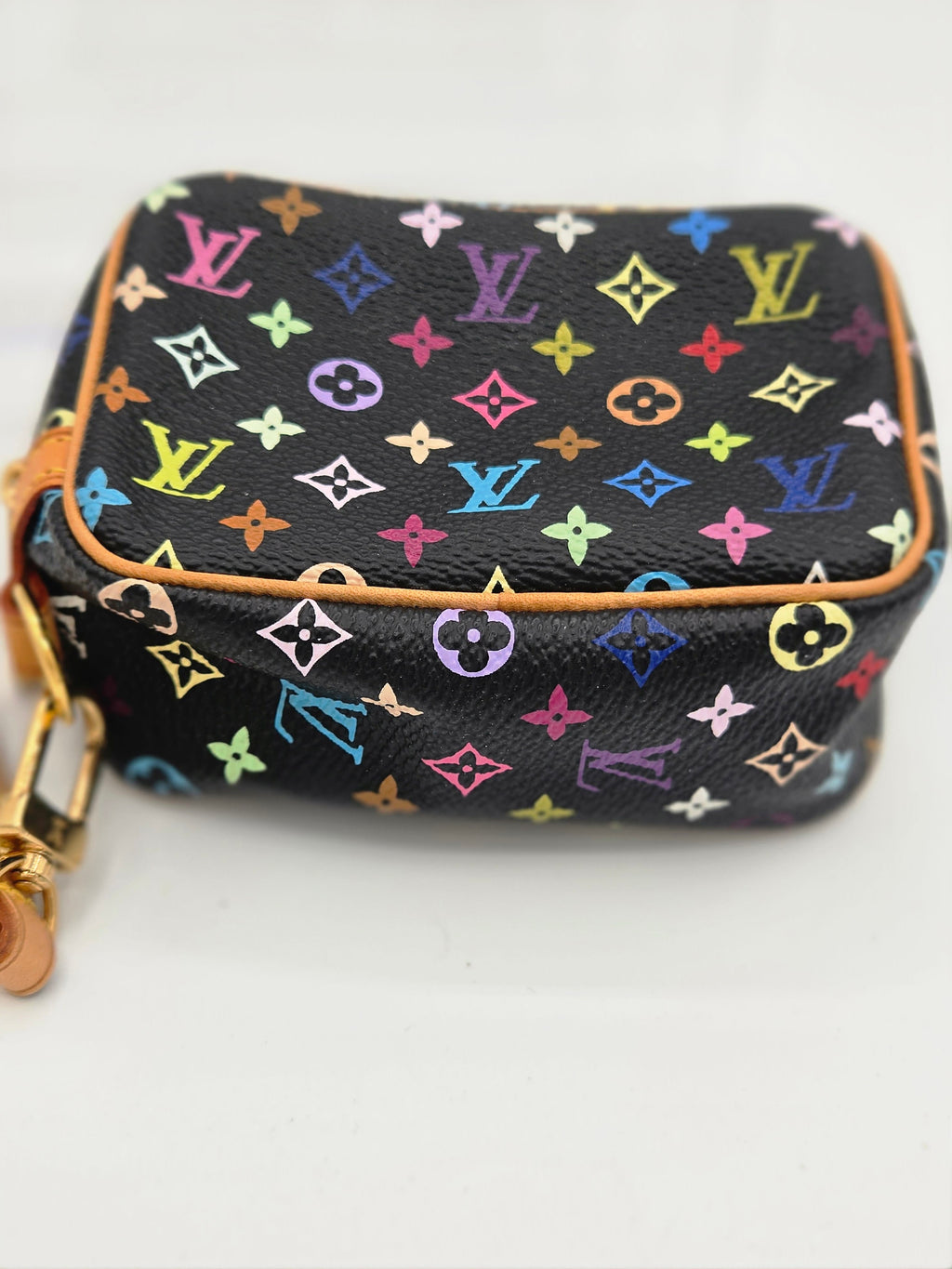 A Louis Vuitton toiletry bag in black coated canvas with a colorful monogram pattern and tan leather trim, shown on a plain white background.
