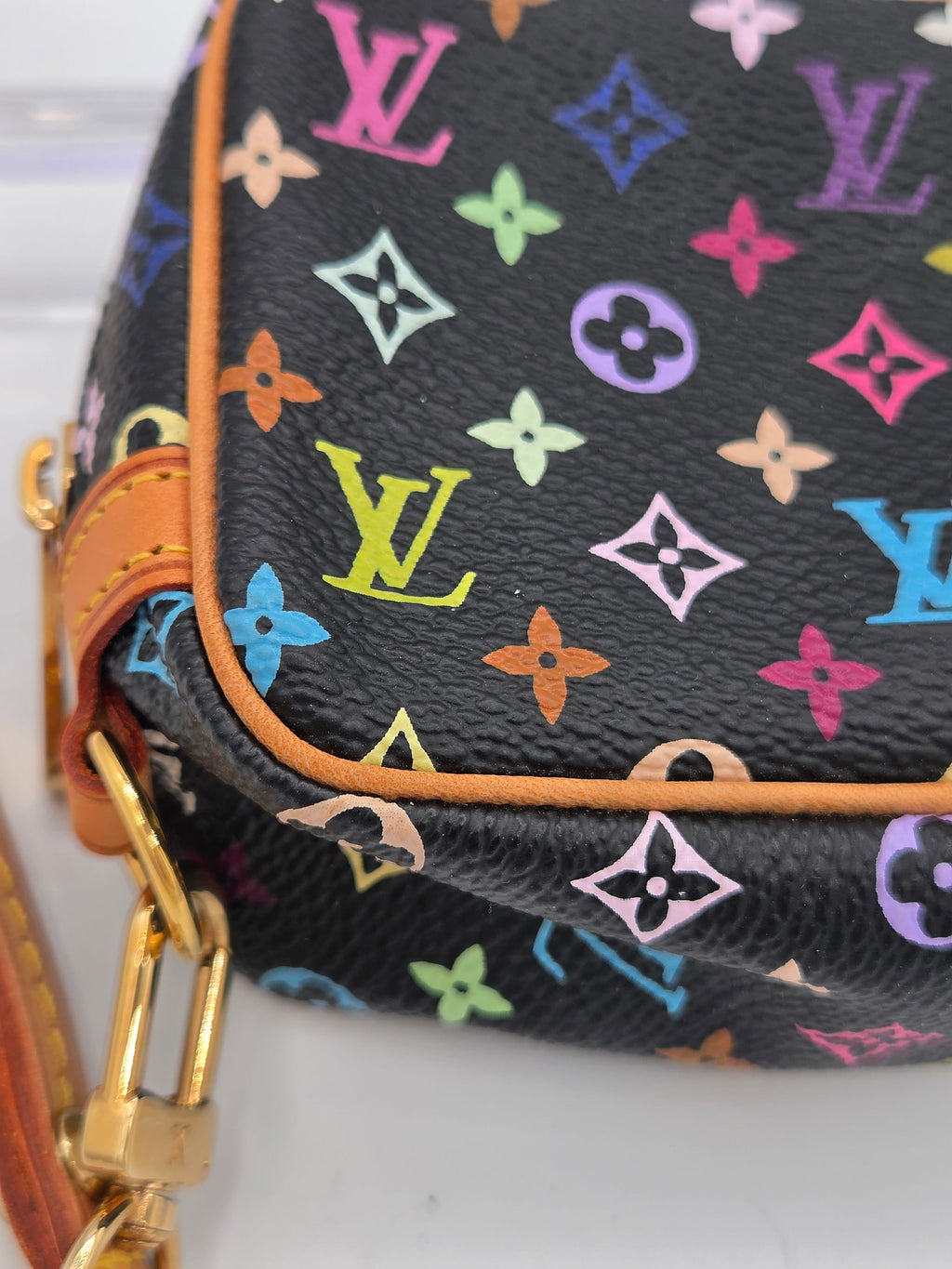 Close-up of a Louis Vuitton handbag in black multicolor monogram canvas with tan leather trim and gold-tone hardware.