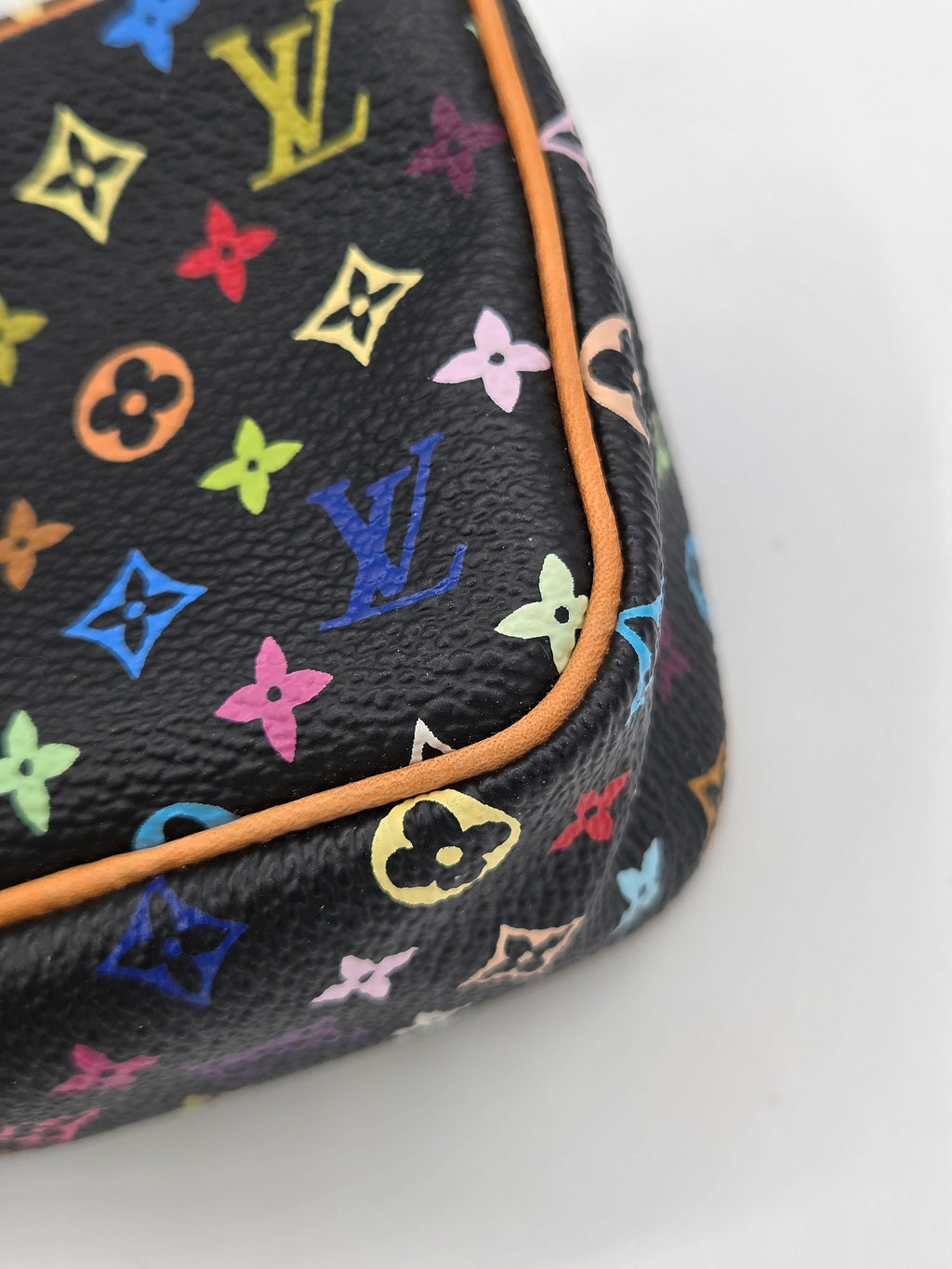 Close-up of a black Louis Vuitton monogram pouch featuring a vibrant multicolor print and orange piping on a white background.