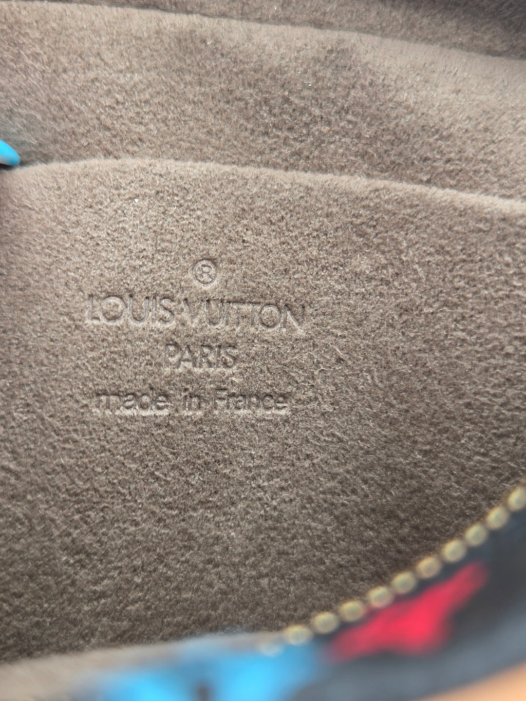 Close-up of a brown suede or nubuck material with embossed 'LOUIS VUITTON PARIS MADE IN FRANCE' text.