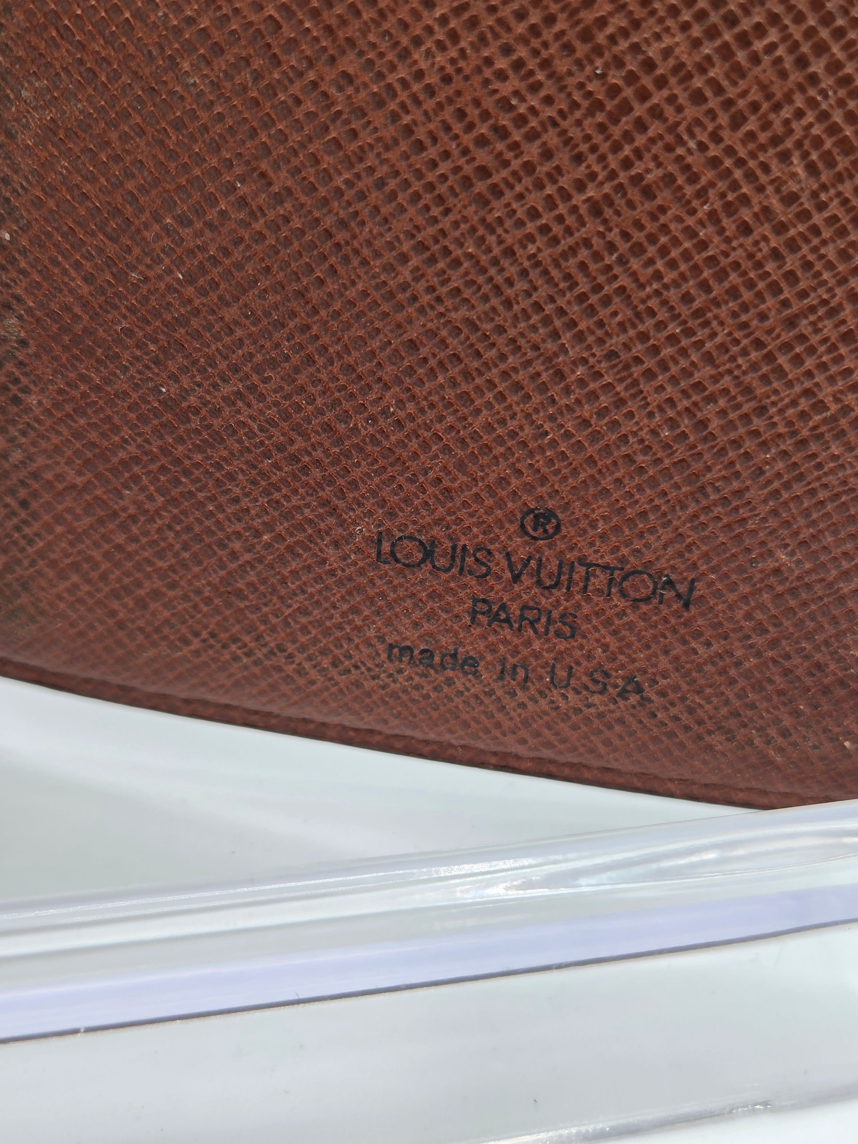 Close-up of a brown textured leather Louis Vuitton item with embossed branding reading 'LOUIS VUITTON PARIS made in U.S.