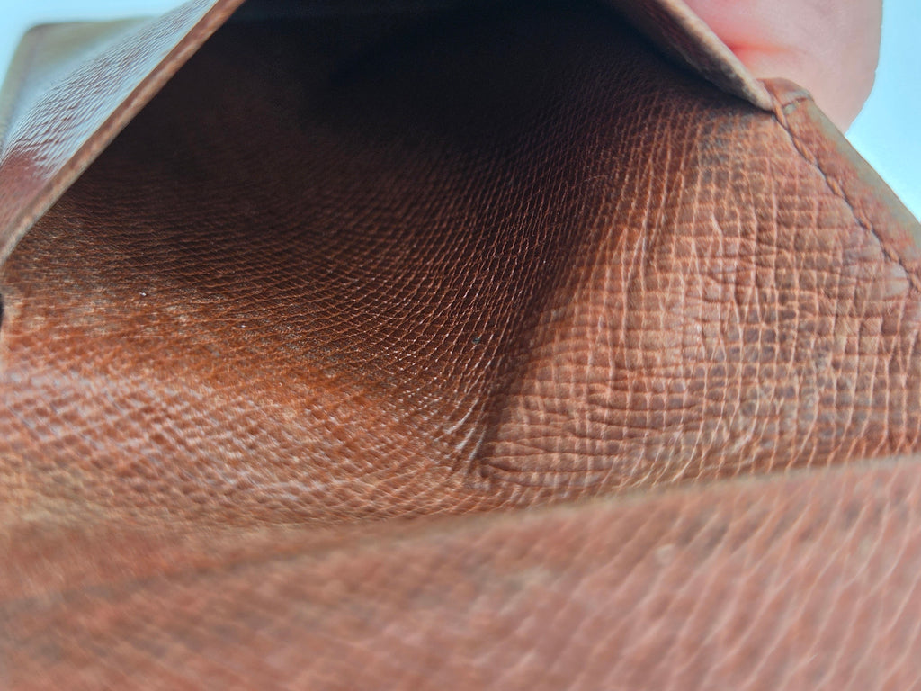 Close-up of a brown textured leather wallet interior showing the grain and stitching details.