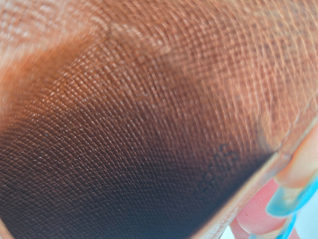Close-up of a brown textured material with a fine woven or mesh-like pattern, partially folded over with a small light-colored edge visible.