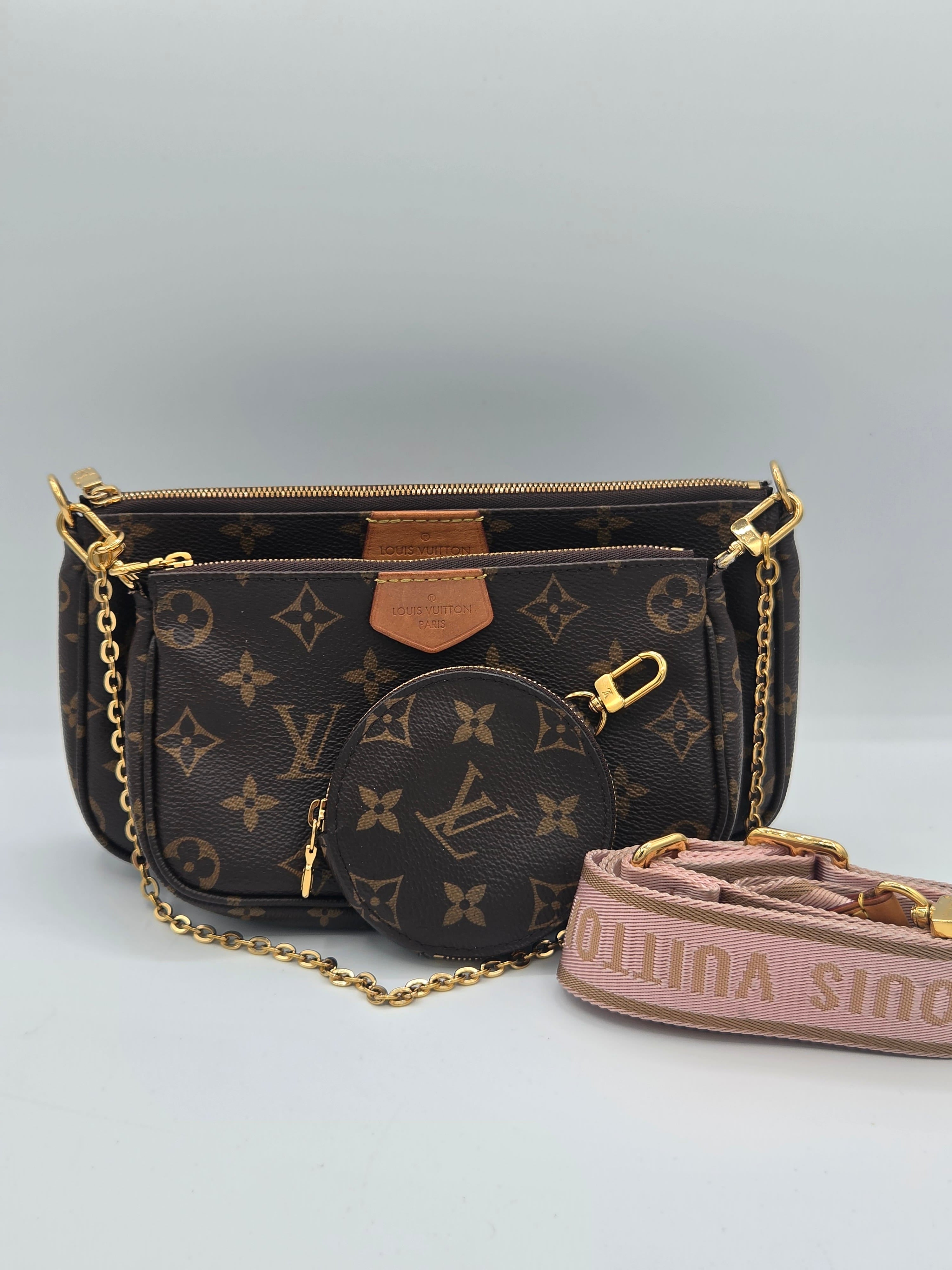 Louis Vuitton monogram canvas shoulder bag with gold-tone chain strap and a pink branded fabric strap, shown against a light gray background.