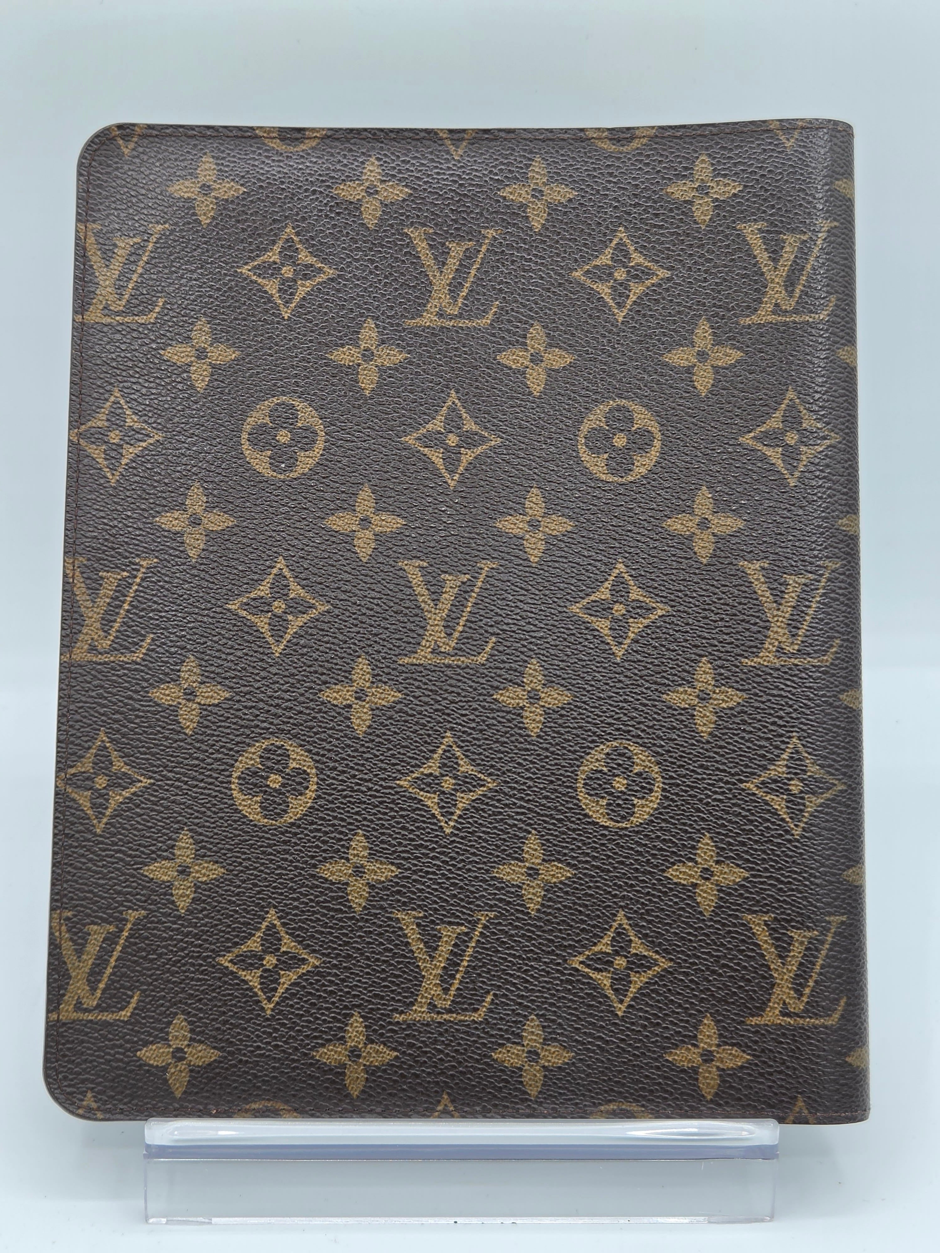 A brown monogram canvas pouch or sleeve with a repeating Louis Vuitton-style LV and floral motif, shown against a plain light background.