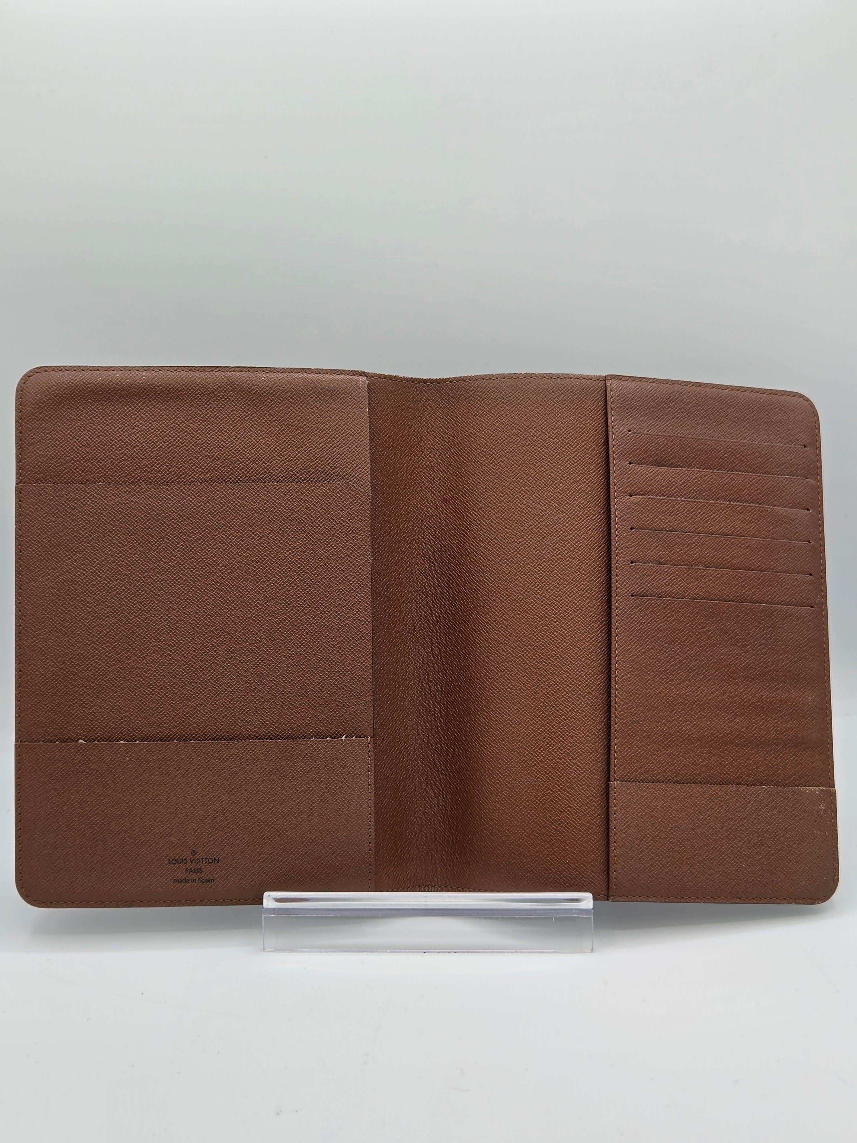 A brown leather wallet shown open, displaying its interior card slots and pocket compartments, photographed against a light gray background.