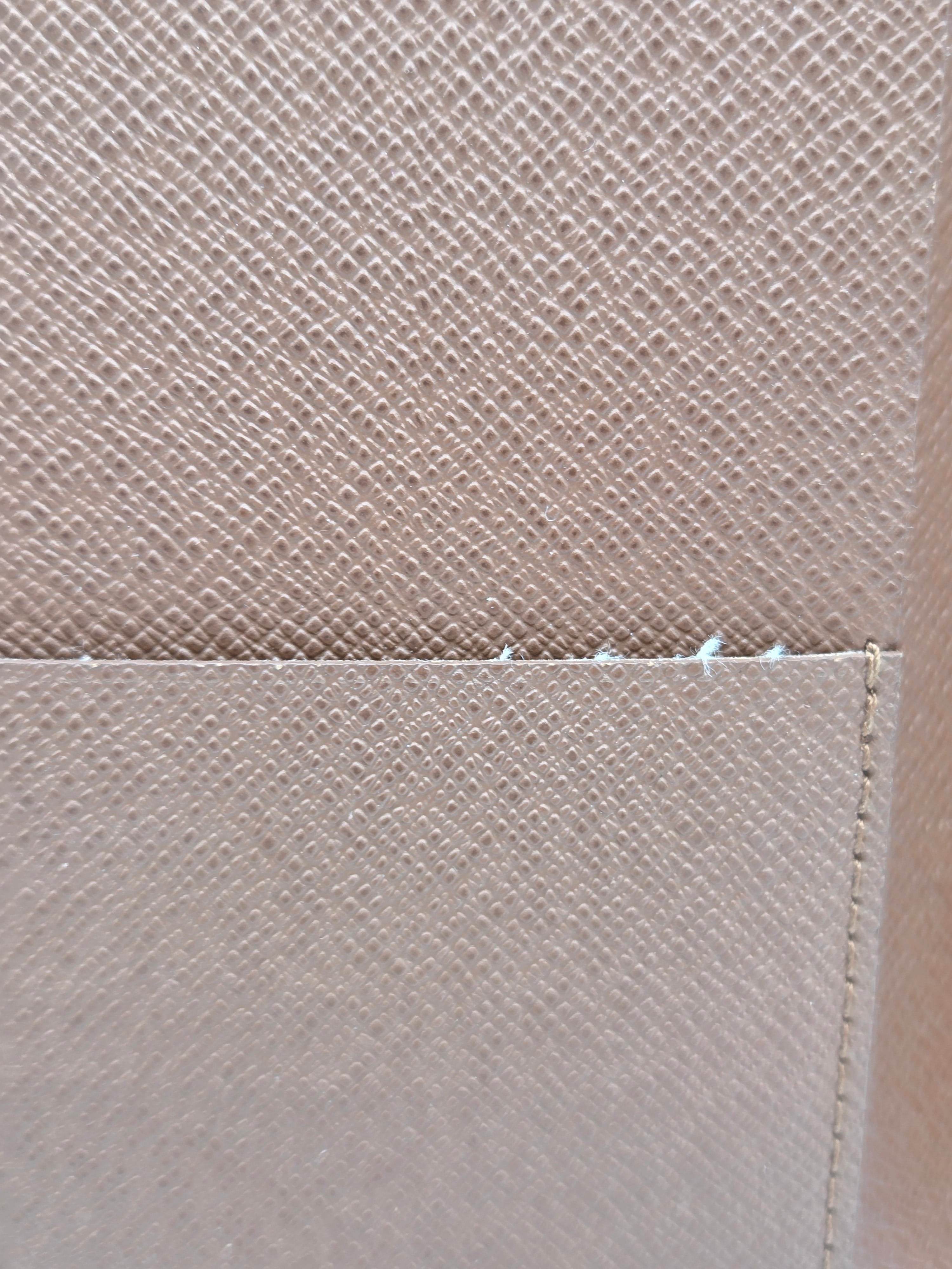 Close-up of a light beige woven fabric with a visible stitched seam and texture.