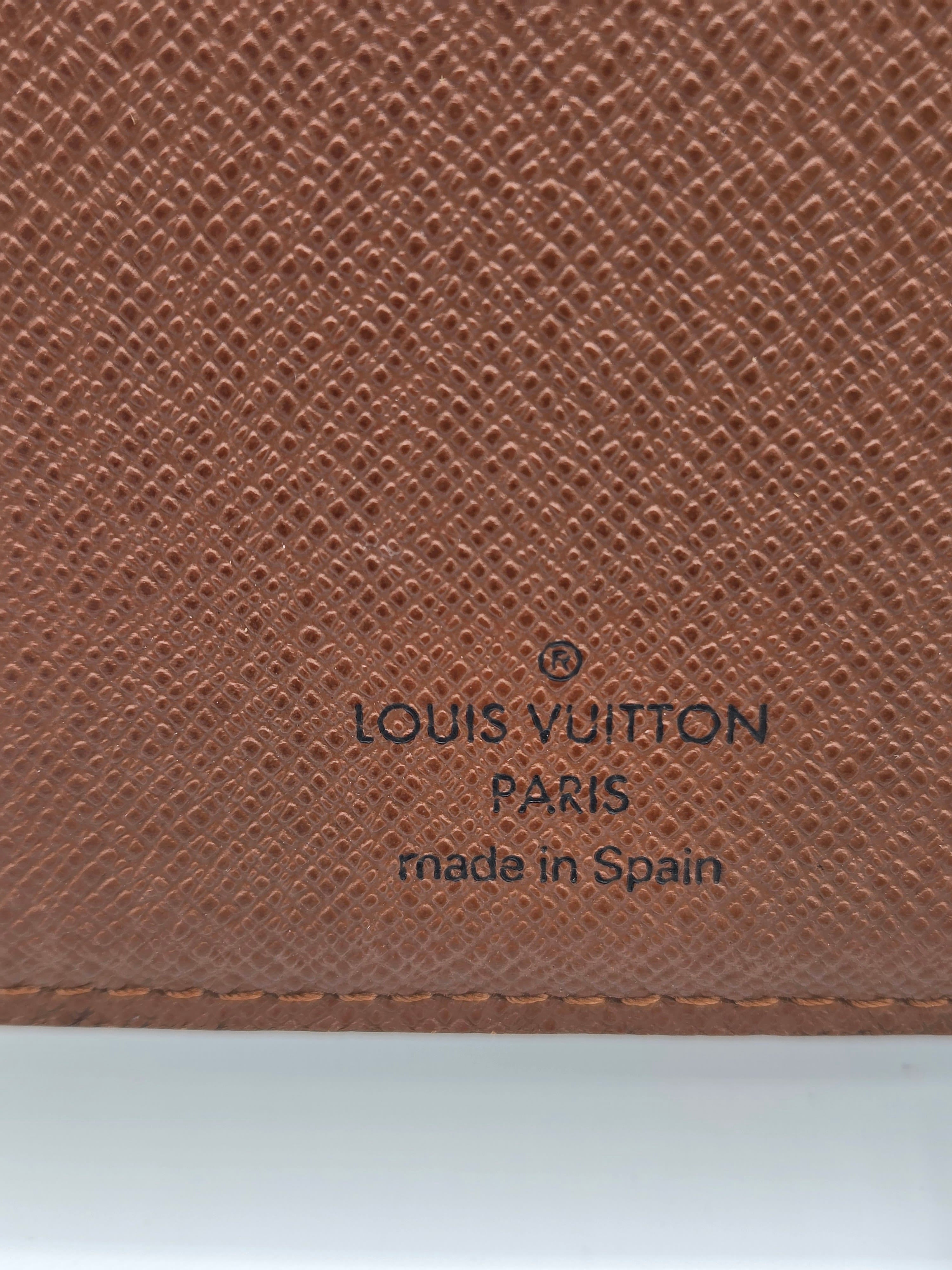 Close-up of a Louis Vuitton brown textured leather item, showing the embossed logo and 'made in Spain' text on a white background.