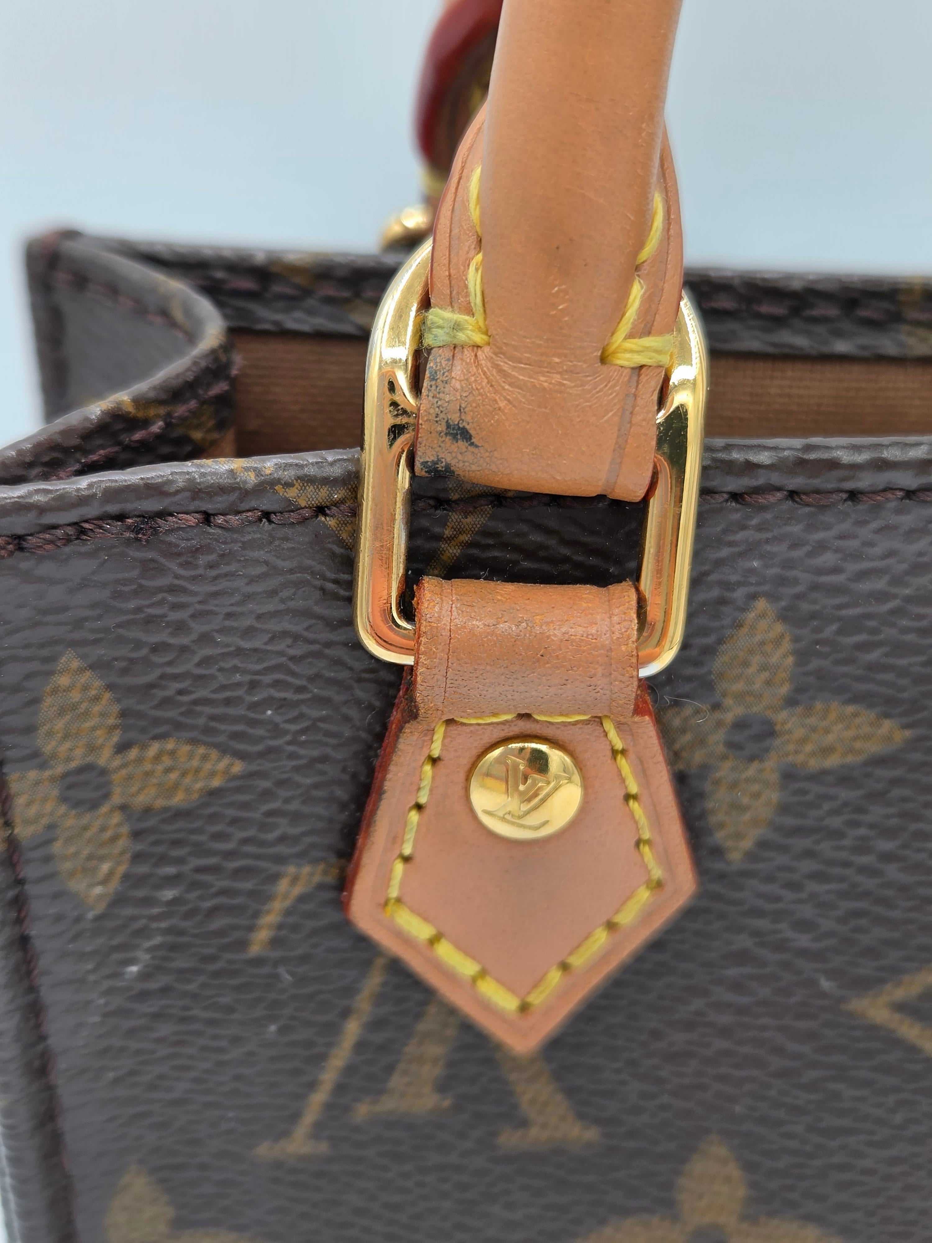 Close-up of a Louis Vuitton handbag featuring the classic brown monogram canvas, tan leather trim, and gold-tone hardware.