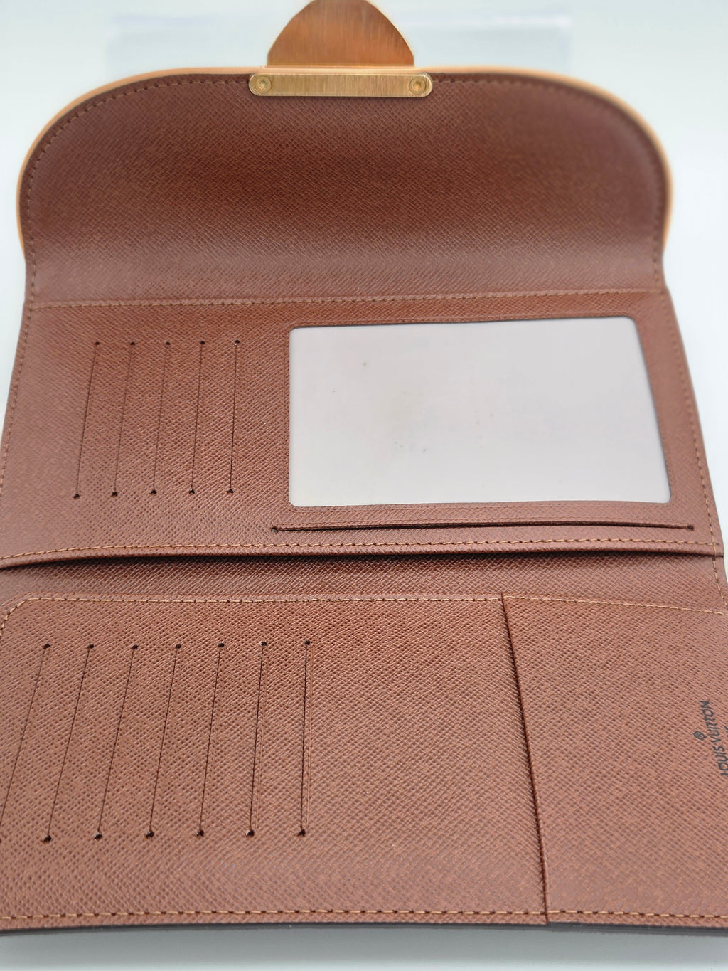 An open brown textured leather wallet or card holder with multiple card slots, a blank ID window, and a small gold-tone metal accent at the top, photographed on a white background.