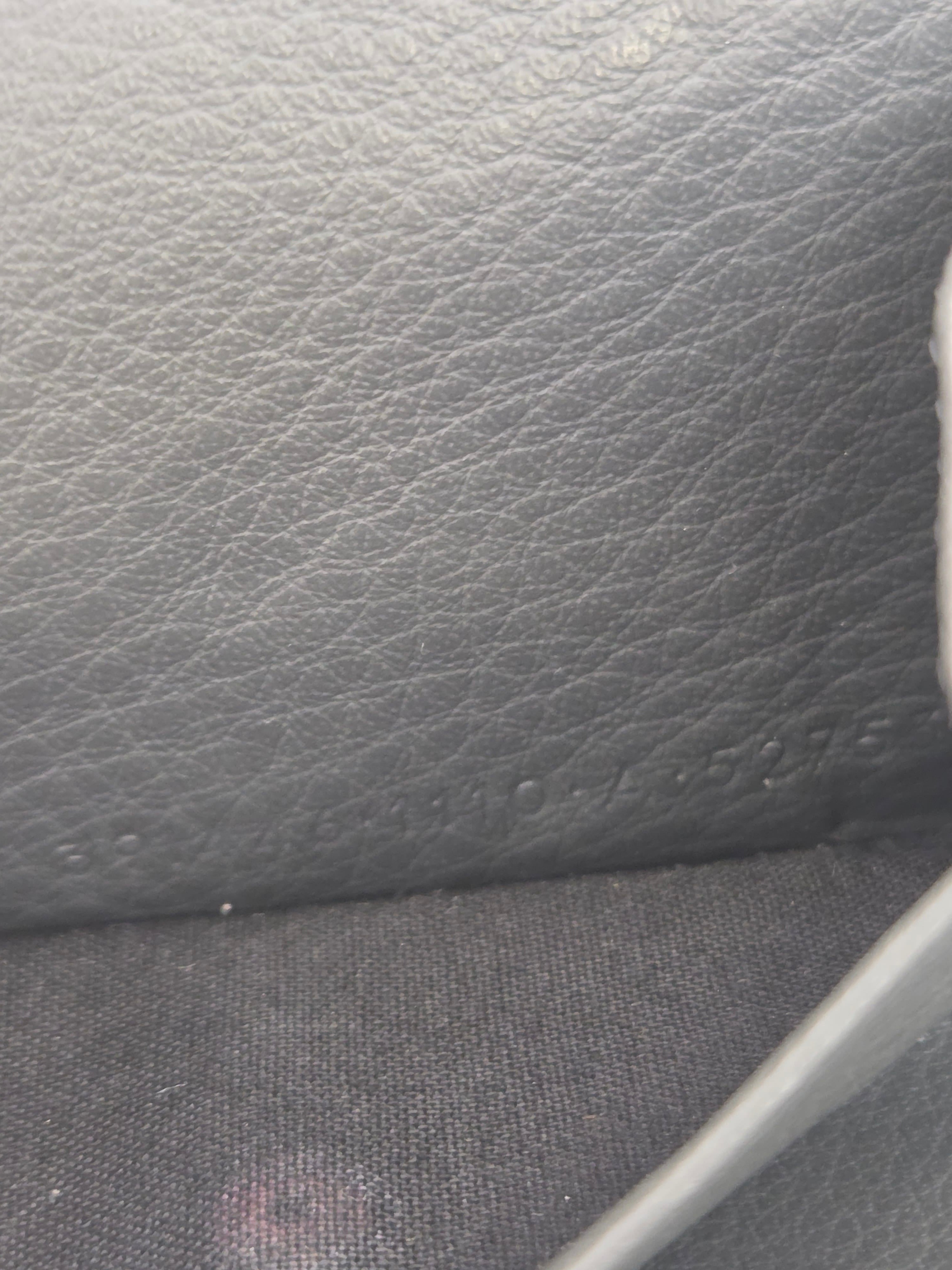 Close-up of a dark gray textured material, showing a pebbled leather-like surface on the left and a woven fabric section on the right.