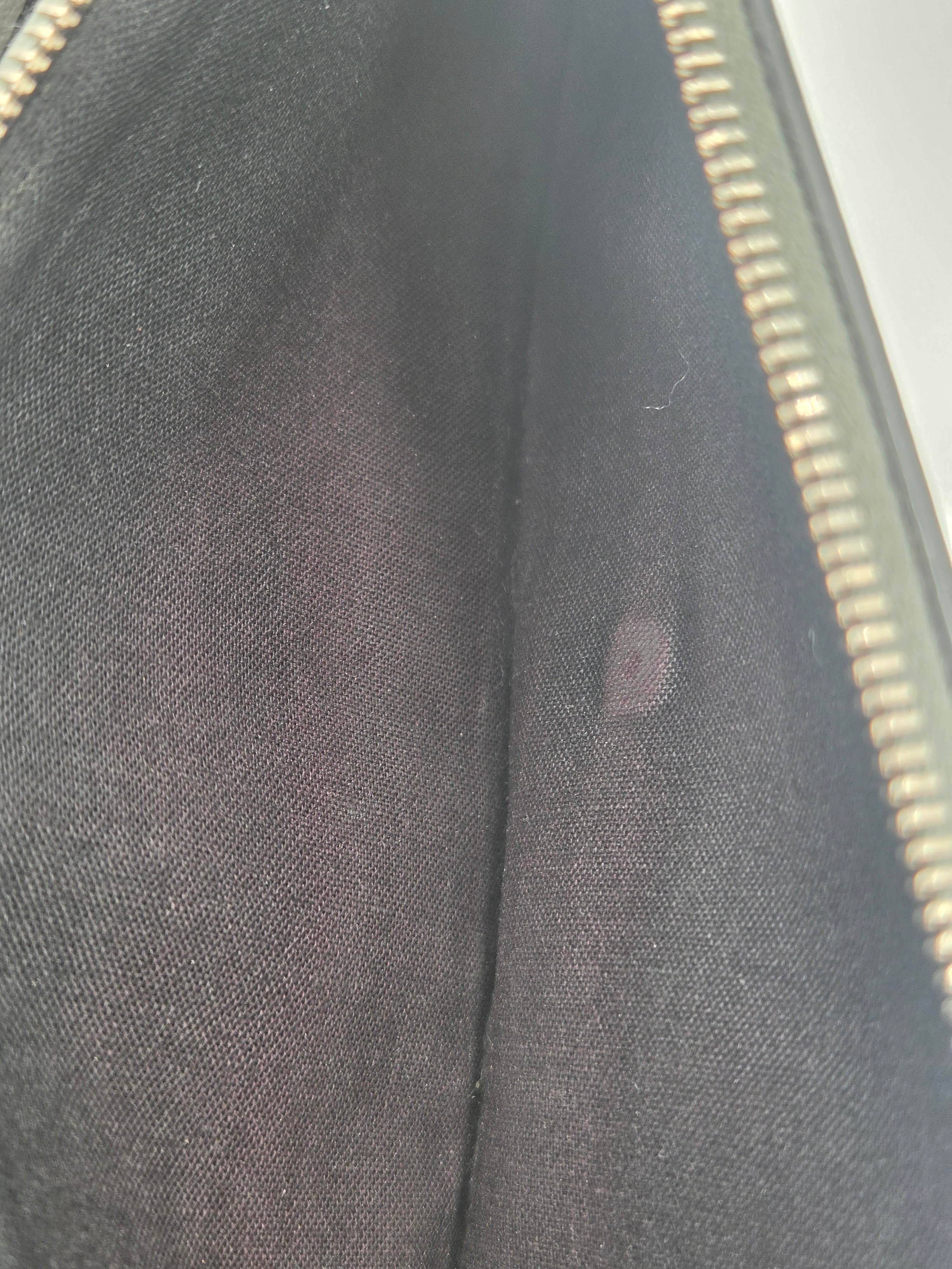 Close-up of a black fabric interior with a gold zipper along the right edge.