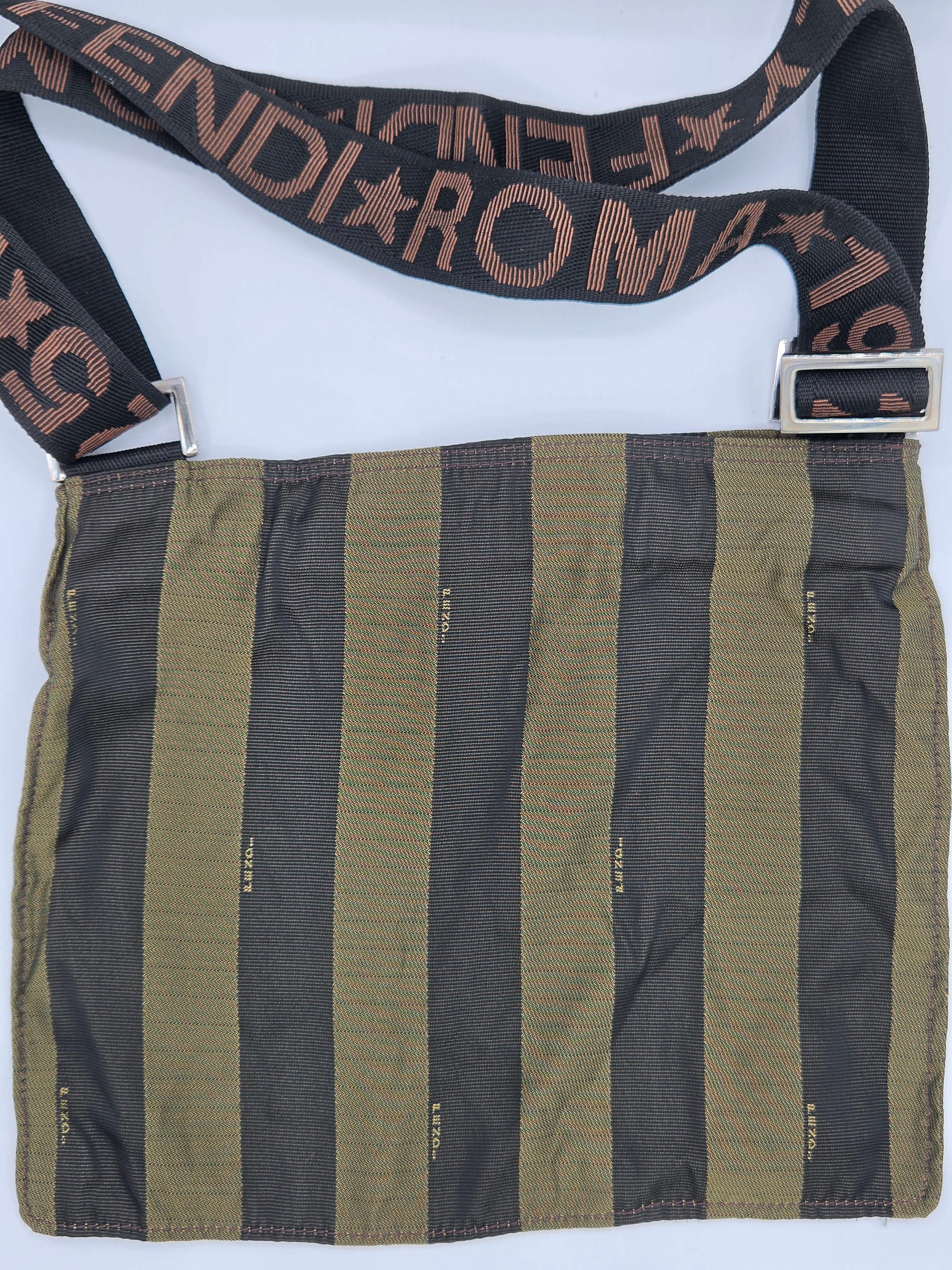 A Fendi shoulder bag with vertical olive green and black stripes on the body, featuring a black strap with 'FENDI ROMA' text in brown, and a silver-tone metal buckle.