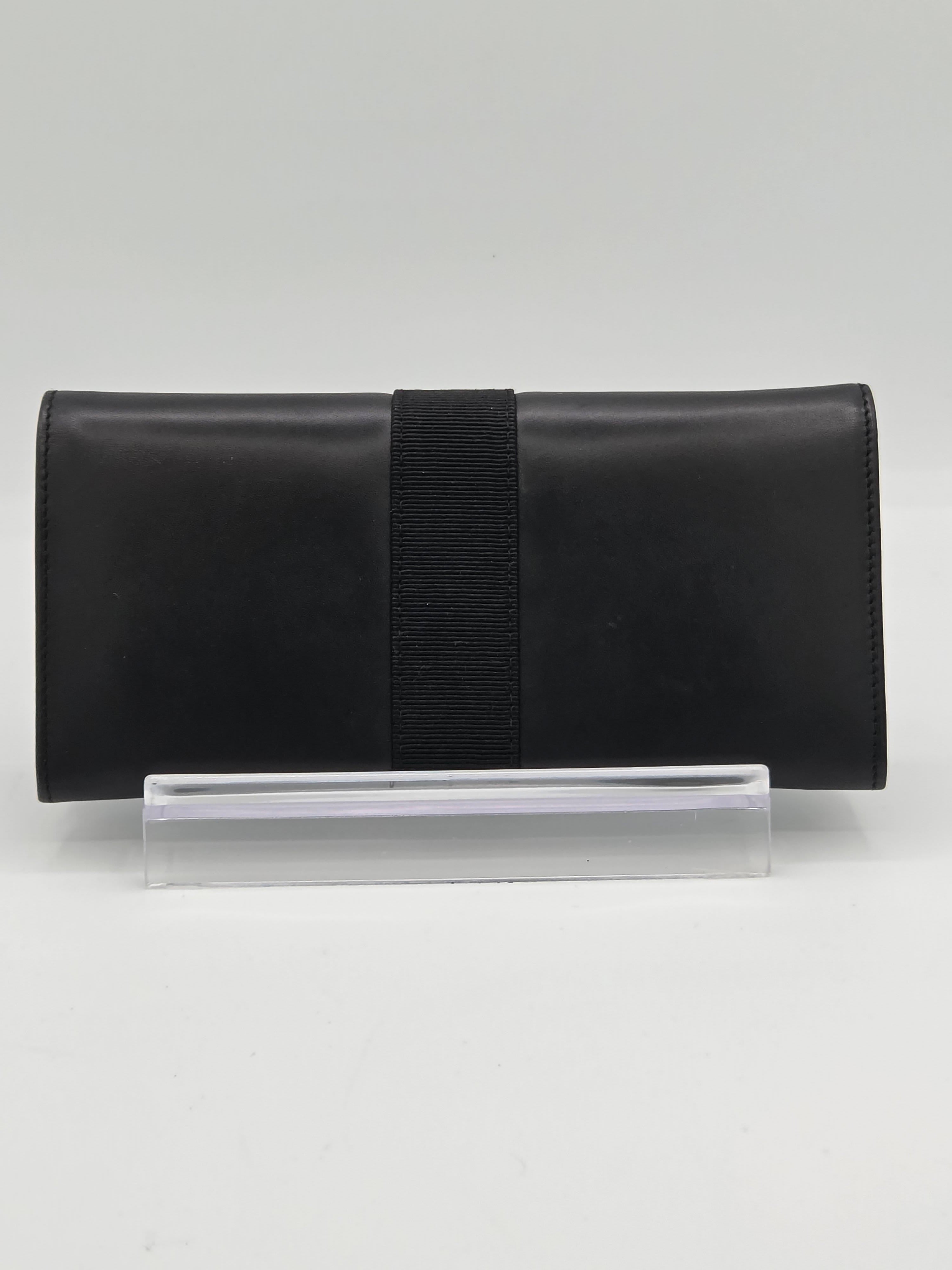 A black leather notebook cover with a black elastic band closure, shown next to a clear plastic sleeve on a light gray background.