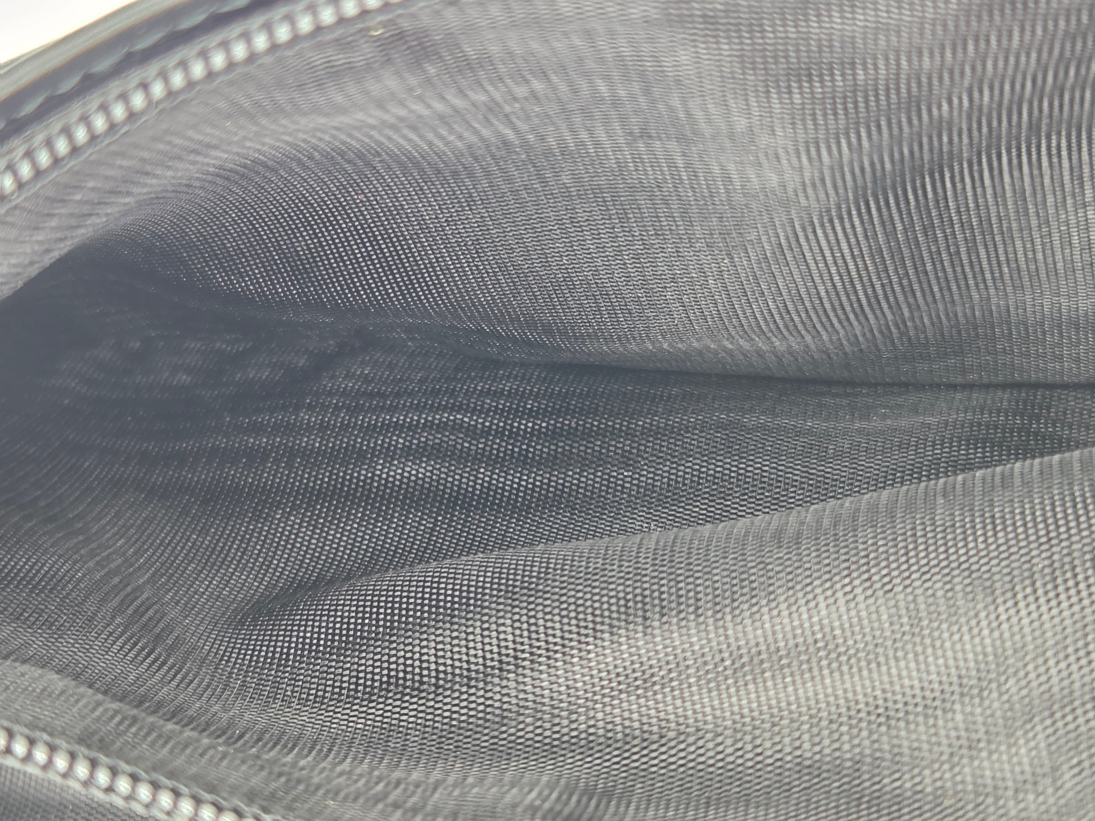 Close-up of a gray woven fabric interior with a zipper edge visible along the top and bottom.