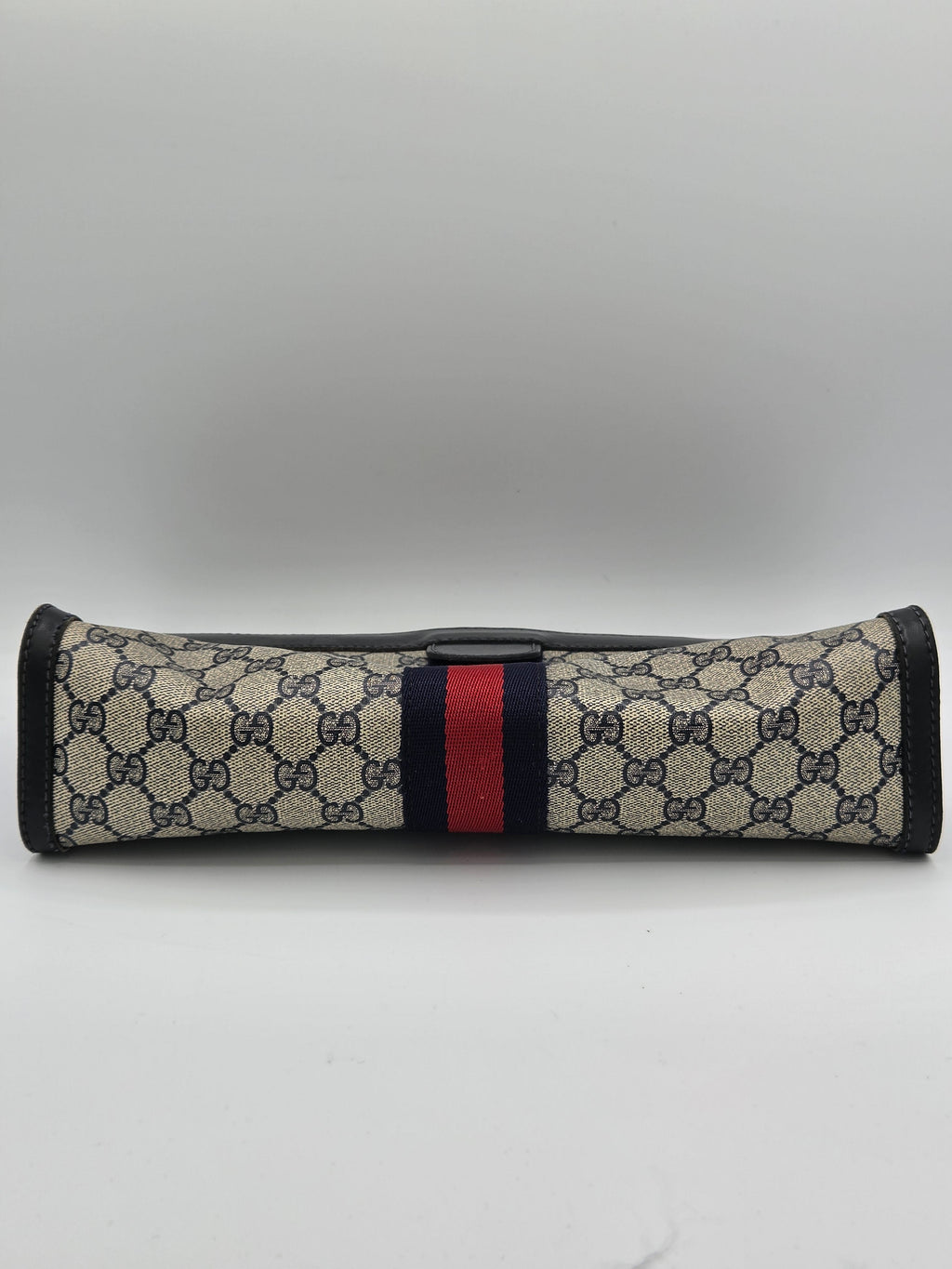 A Gucci sleeve featuring the brand's signature GG Supreme monogram pattern in beige and black, with a classic green and red web stripe down the center, and black trim.