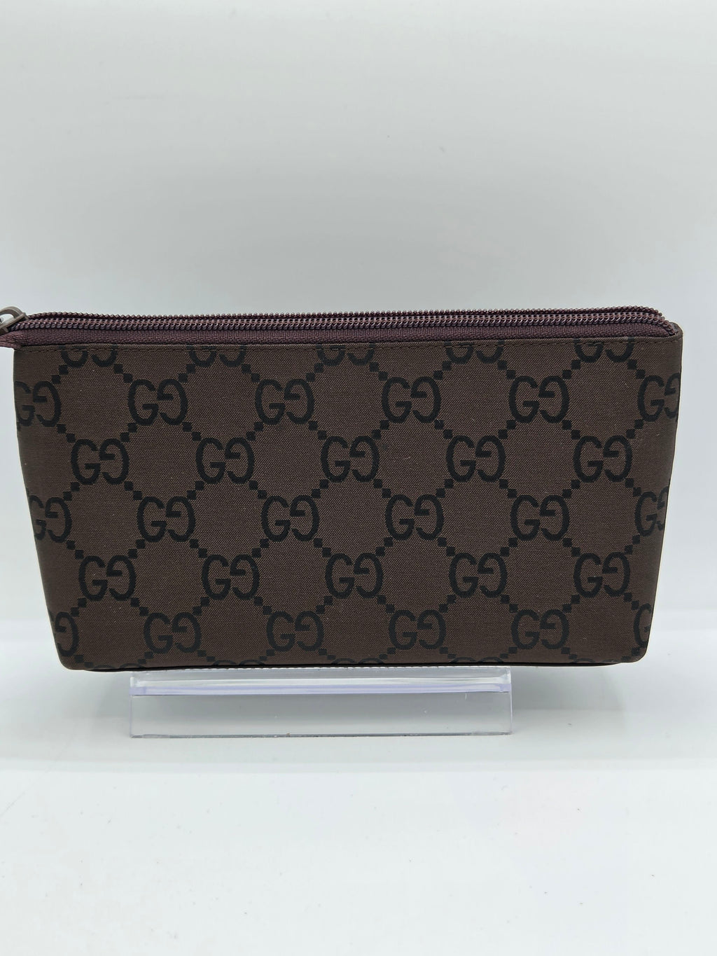 A brown monogram zip-around wallet with a dark brown GG pattern, shown standing upright against a plain white background.