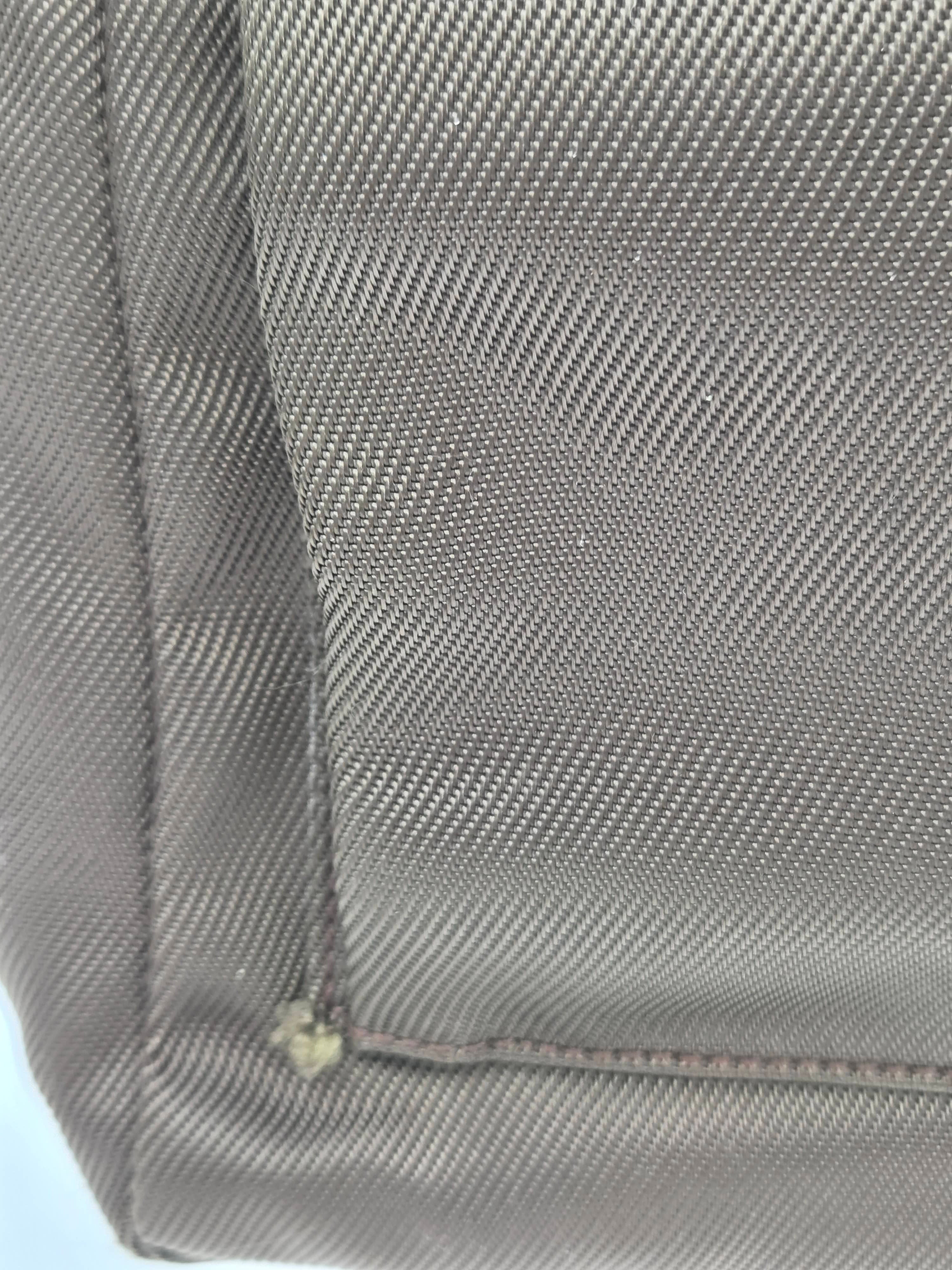 Close-up of a gray textured fabric surface with diagonal woven pattern and a visible seam.