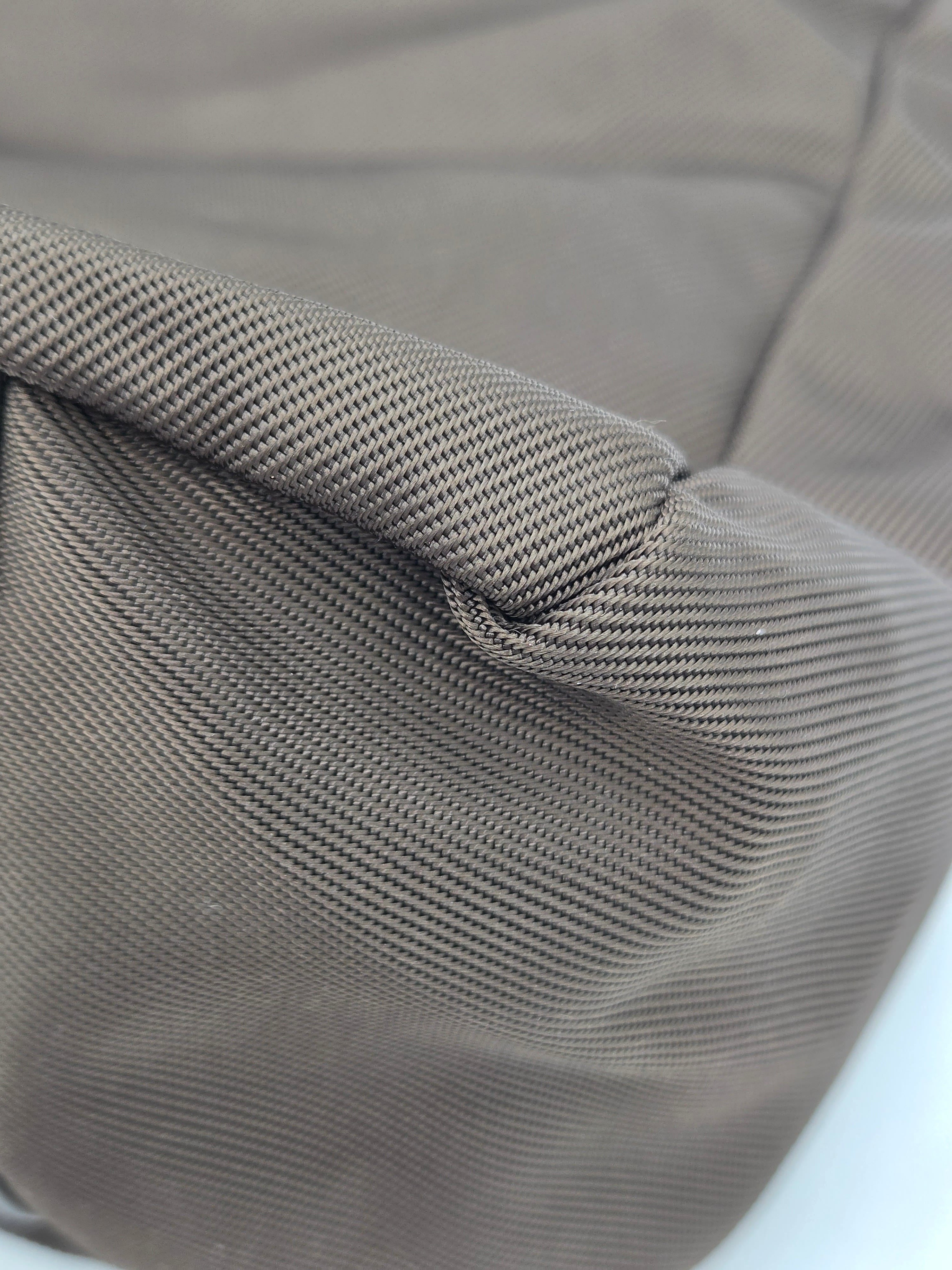 Close-up of a gray ribbed fabric texture with a visible fold and stitched seam.